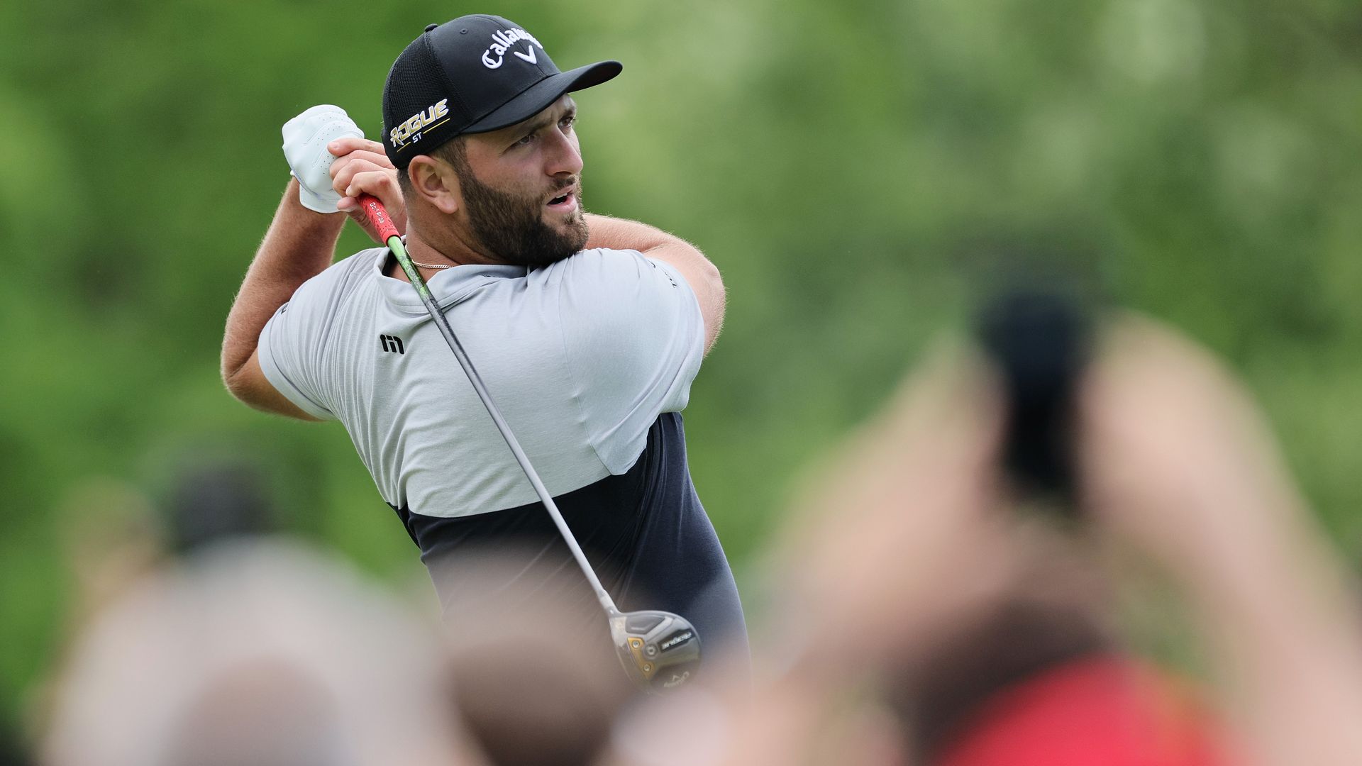 Jon Rahm watches his shot after swinging