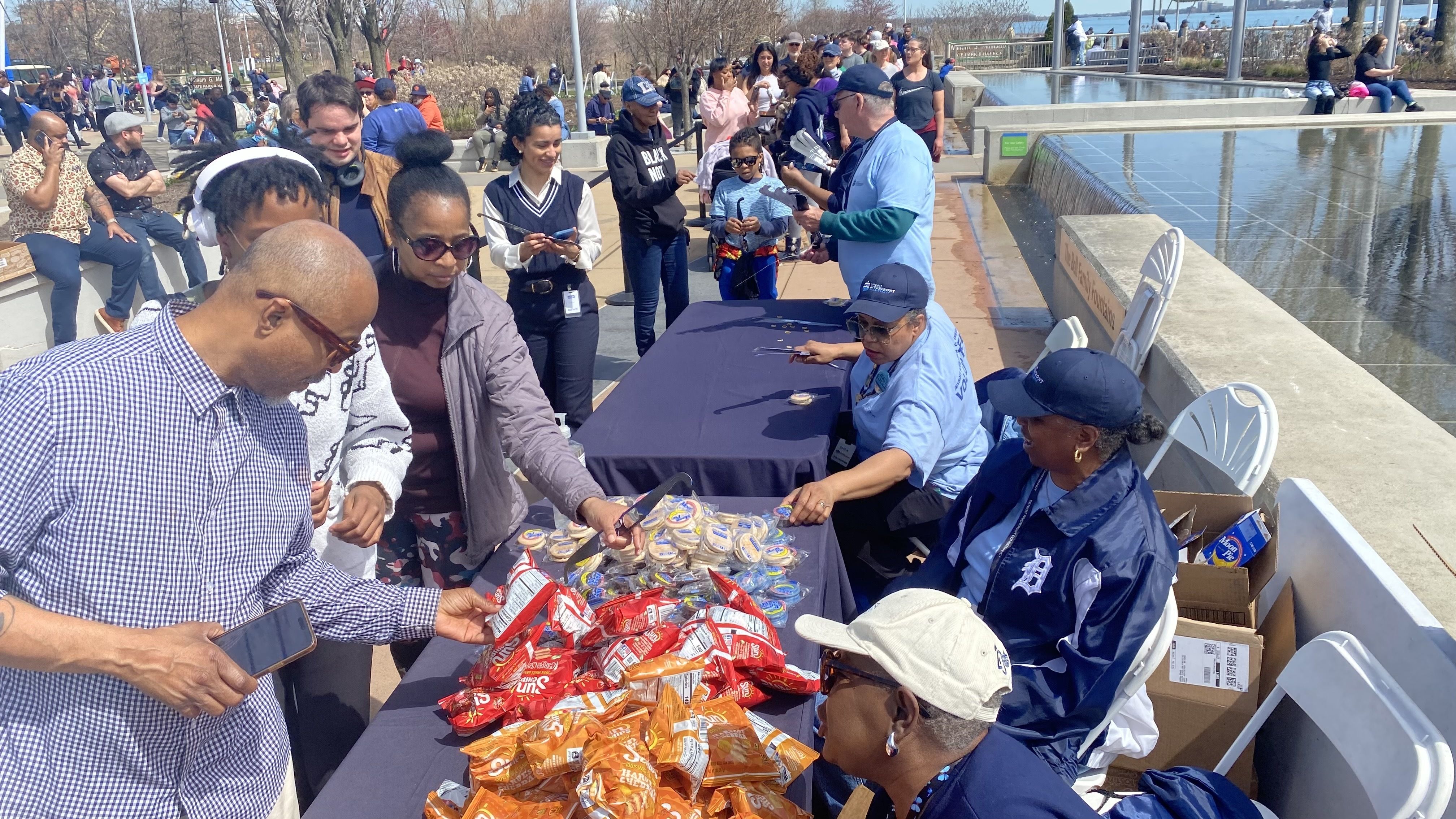 People grab snacks from a table amid a long, long line.