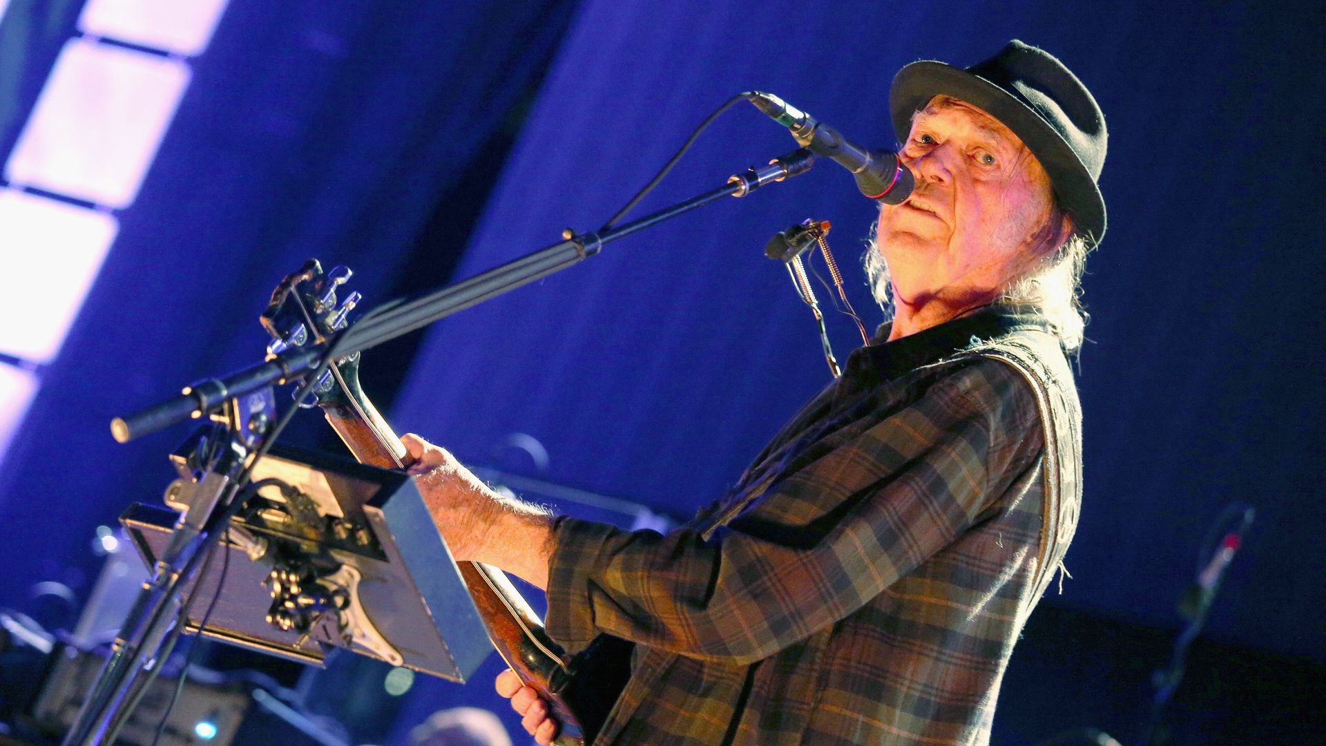 Neil Young wears flannel and plays the guitar 