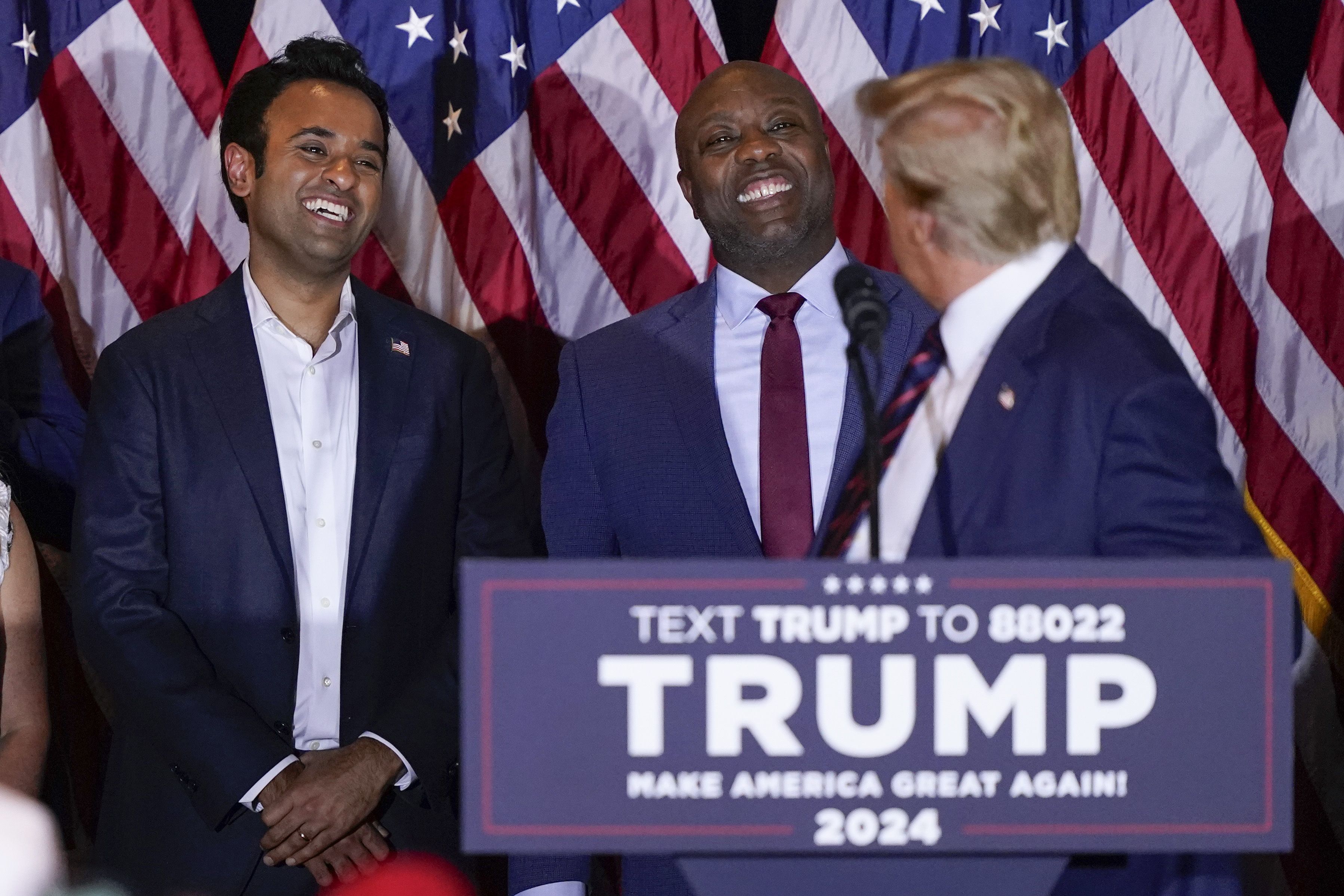 Sen. Tim Scott and Vivek Ramaswamy appear behind former President Trump during his New Hampshire victory speech.