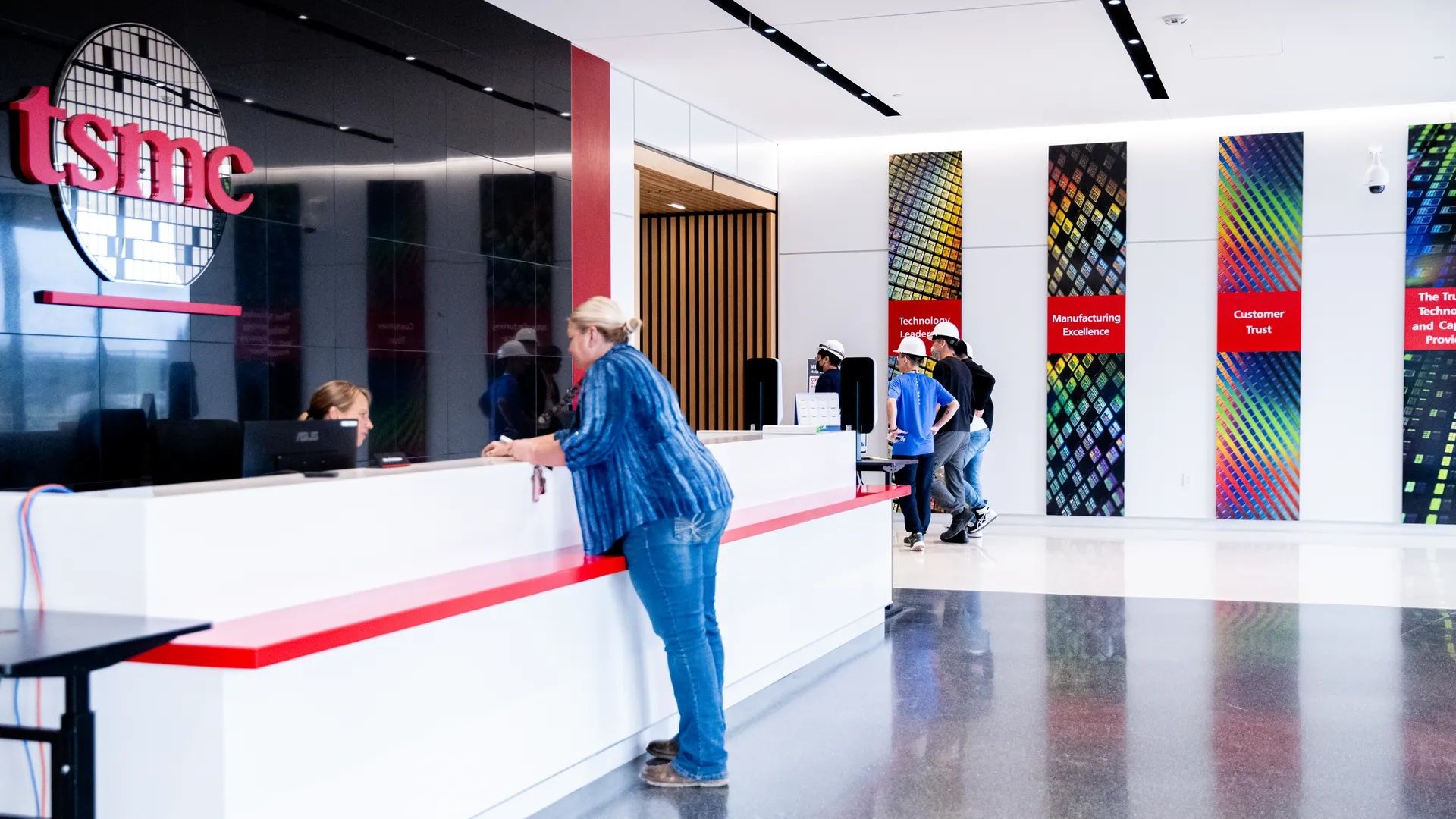 Photo of a lobby of a place of business with "TSMC" logo over the desk