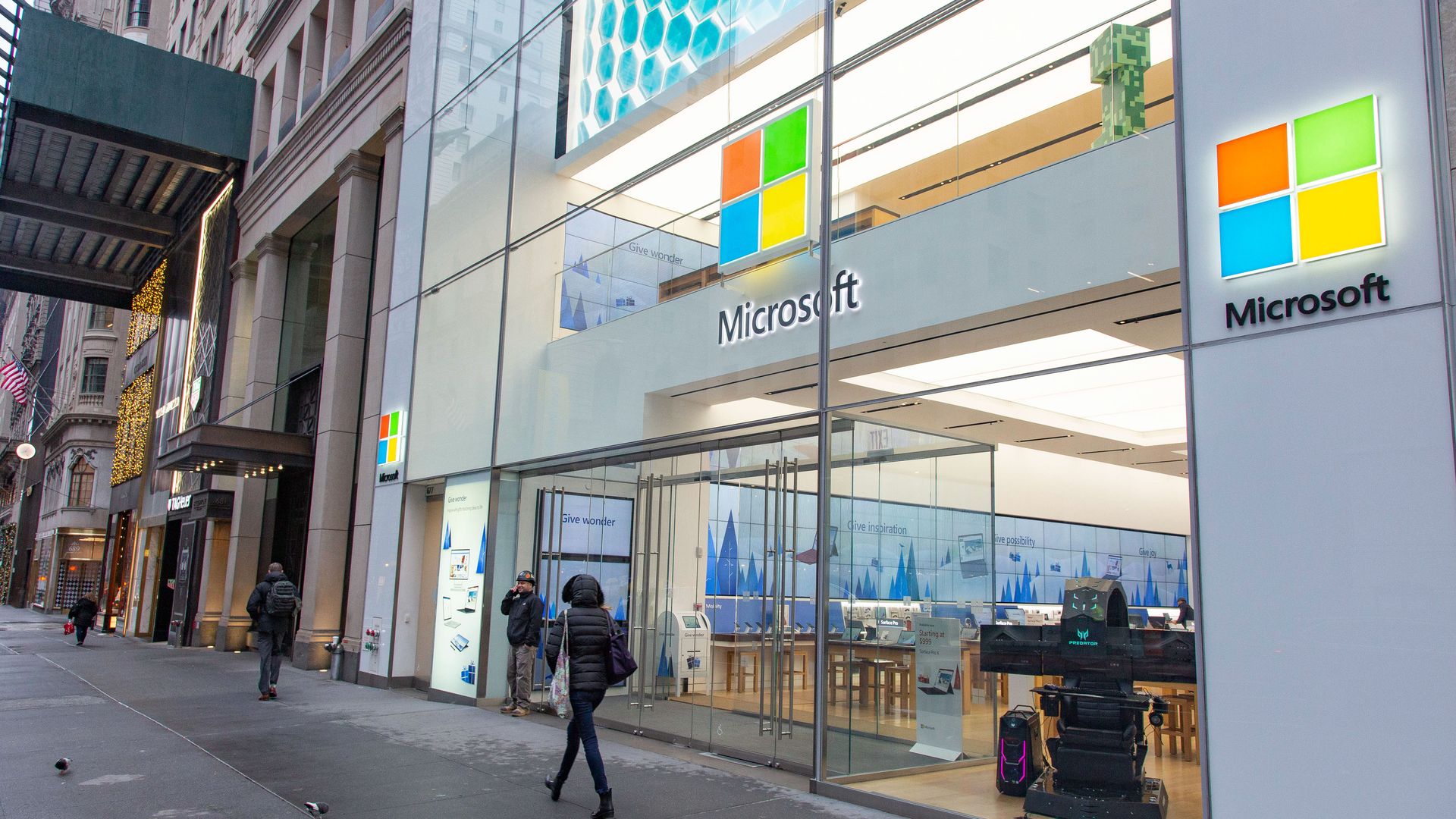 In this image, a woman walks past a Microsoft store