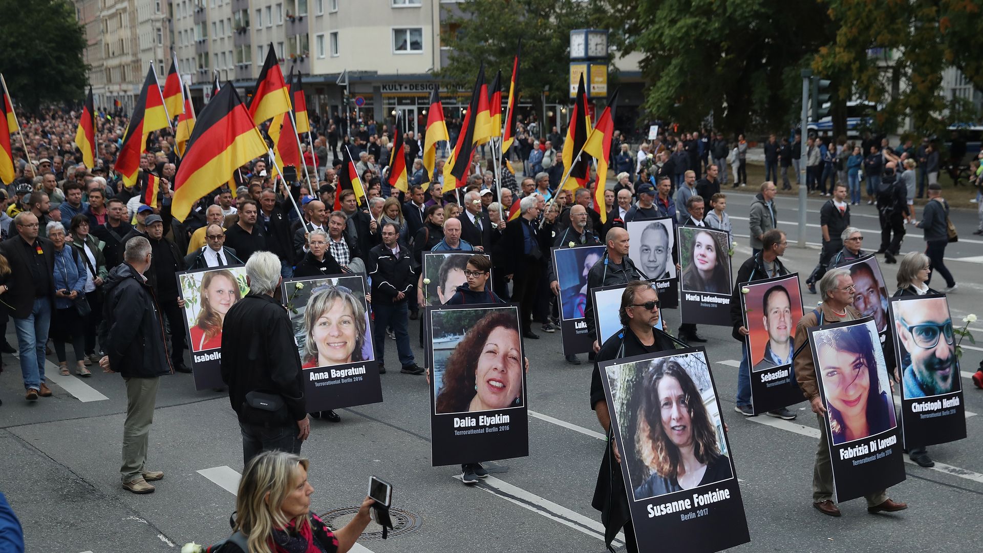 Protestors carrying German flags and portraits of people killed by migrants