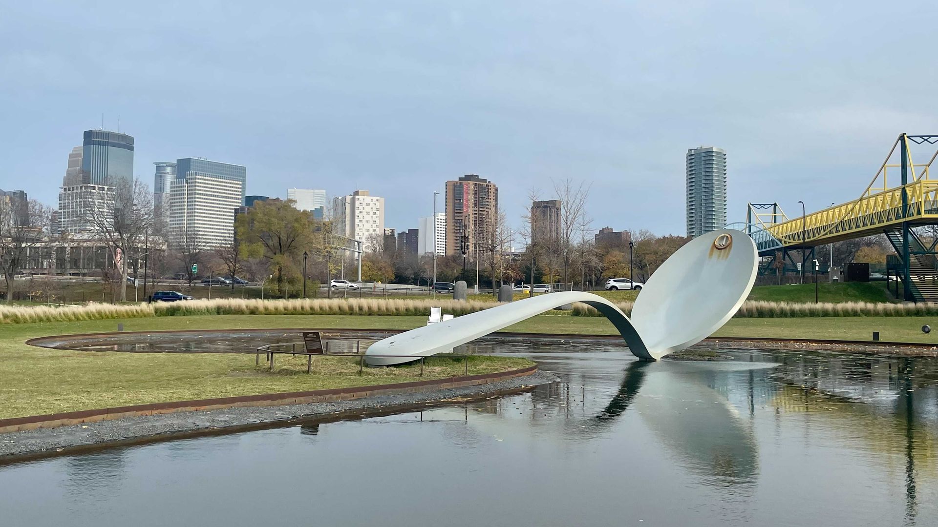 giant spoon sculpture in a pond in front of minneapolis skyline 