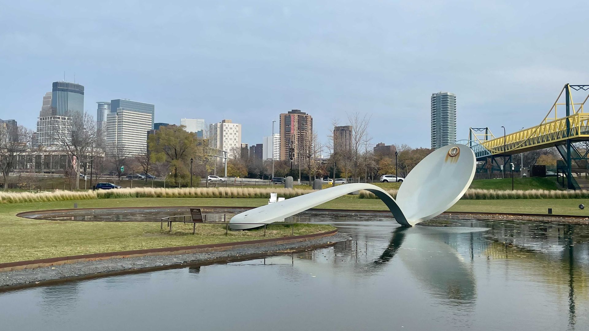 giant spoon sculpture in a pond in front of minneapolis skyline