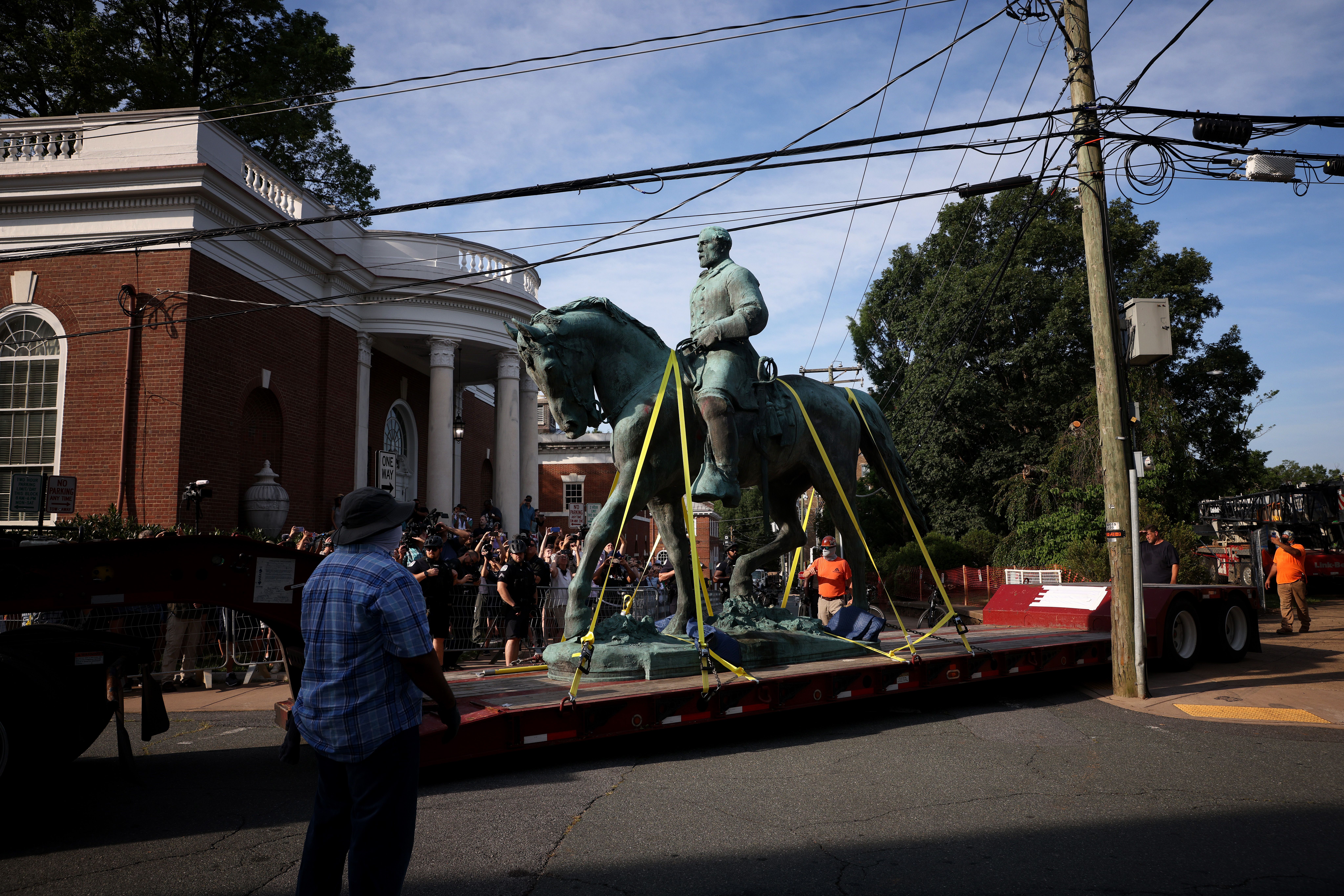 A flatbed truck carries a statue of Confederate General Robert E. Lee from the Market Street Park July 10