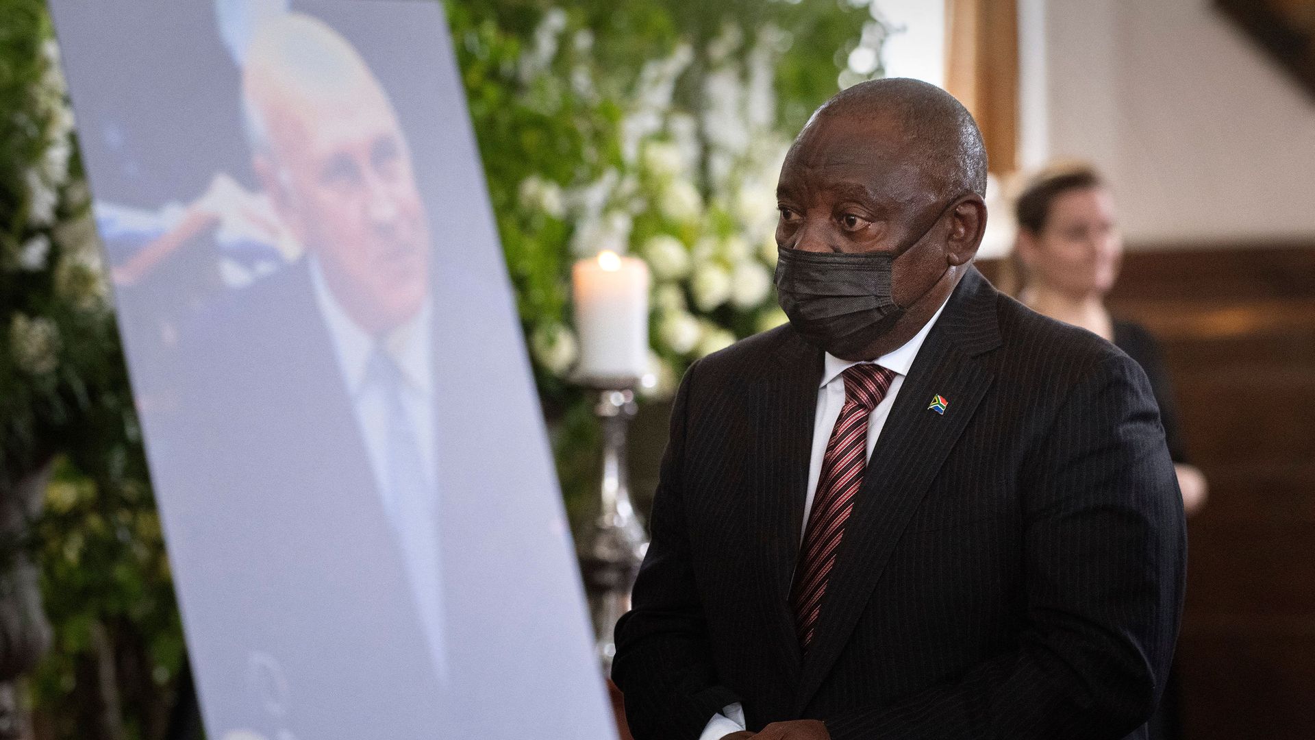 South African President Cyril Ramaphosa walks past a photo of former South African President FW de Klerk at de Klerk's state memorial service 