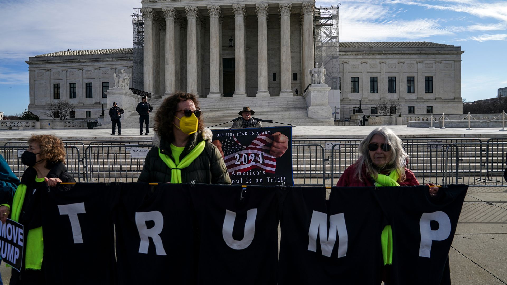 Photo of demonstrators holding a "Trump" sign outside the Supreme Court building