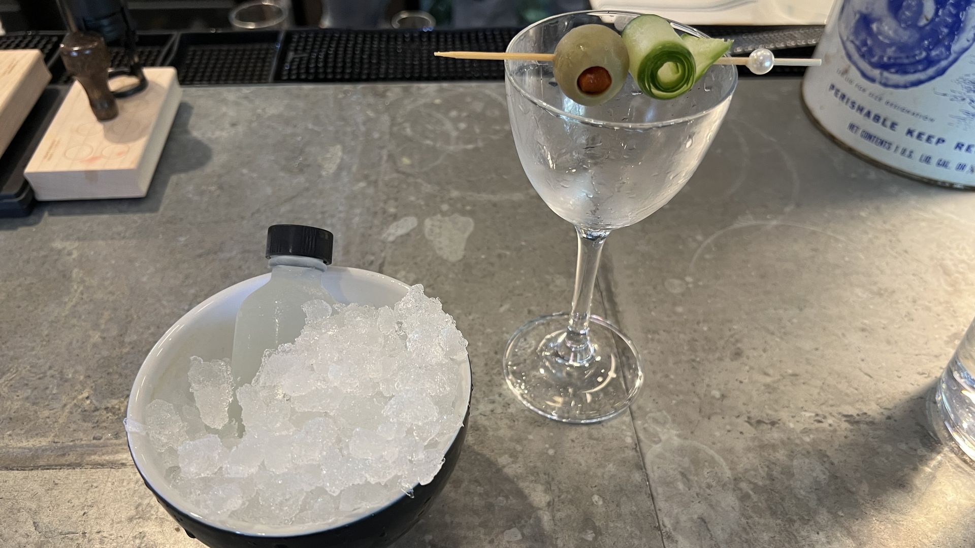 a vial in a bowl of ice and an empty martini glass