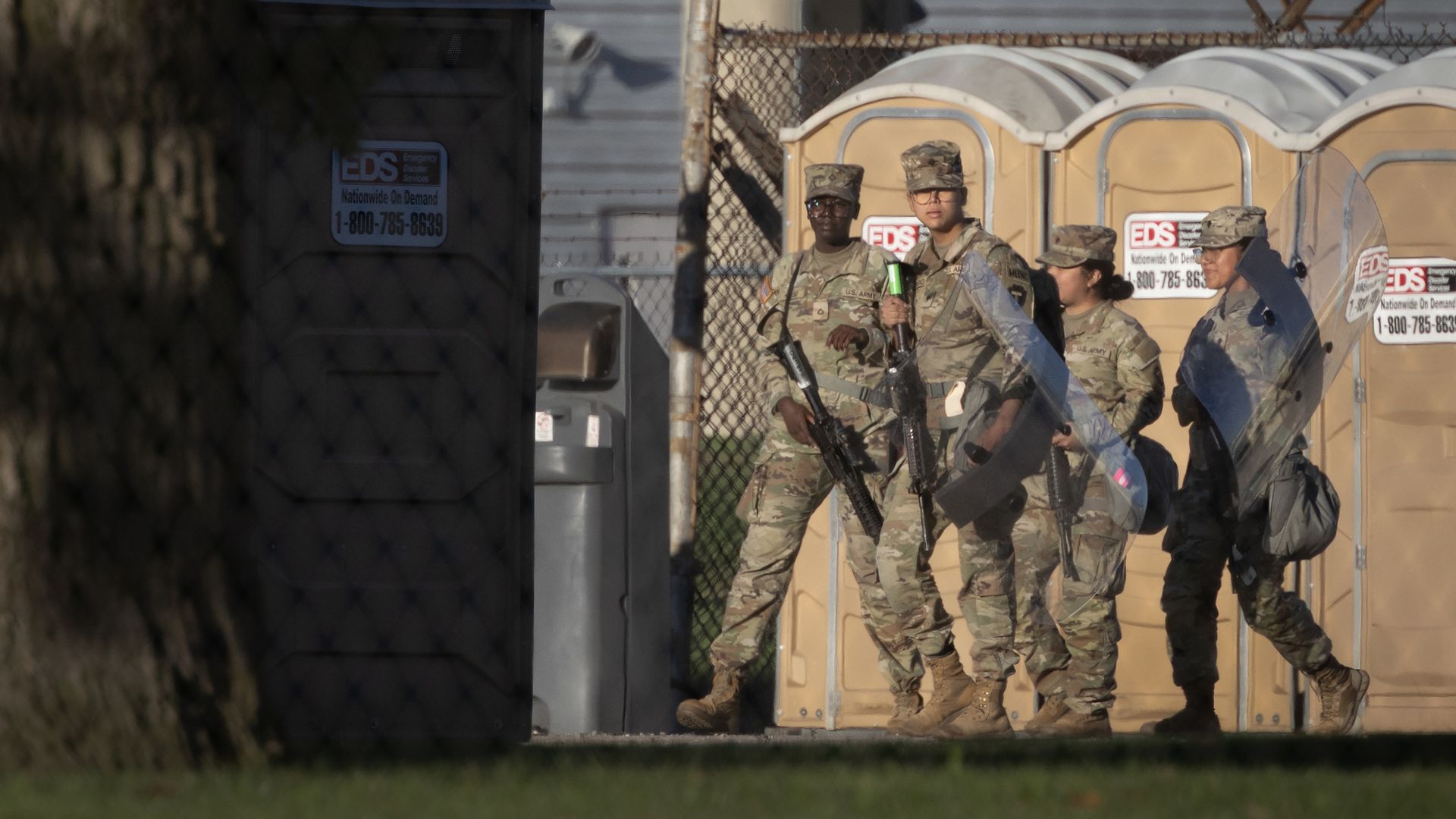 Members of the Texas National Guard carry rifles and riot shields at an army reserve training facility on October 07, 2025 in Elwood, Illinois.
