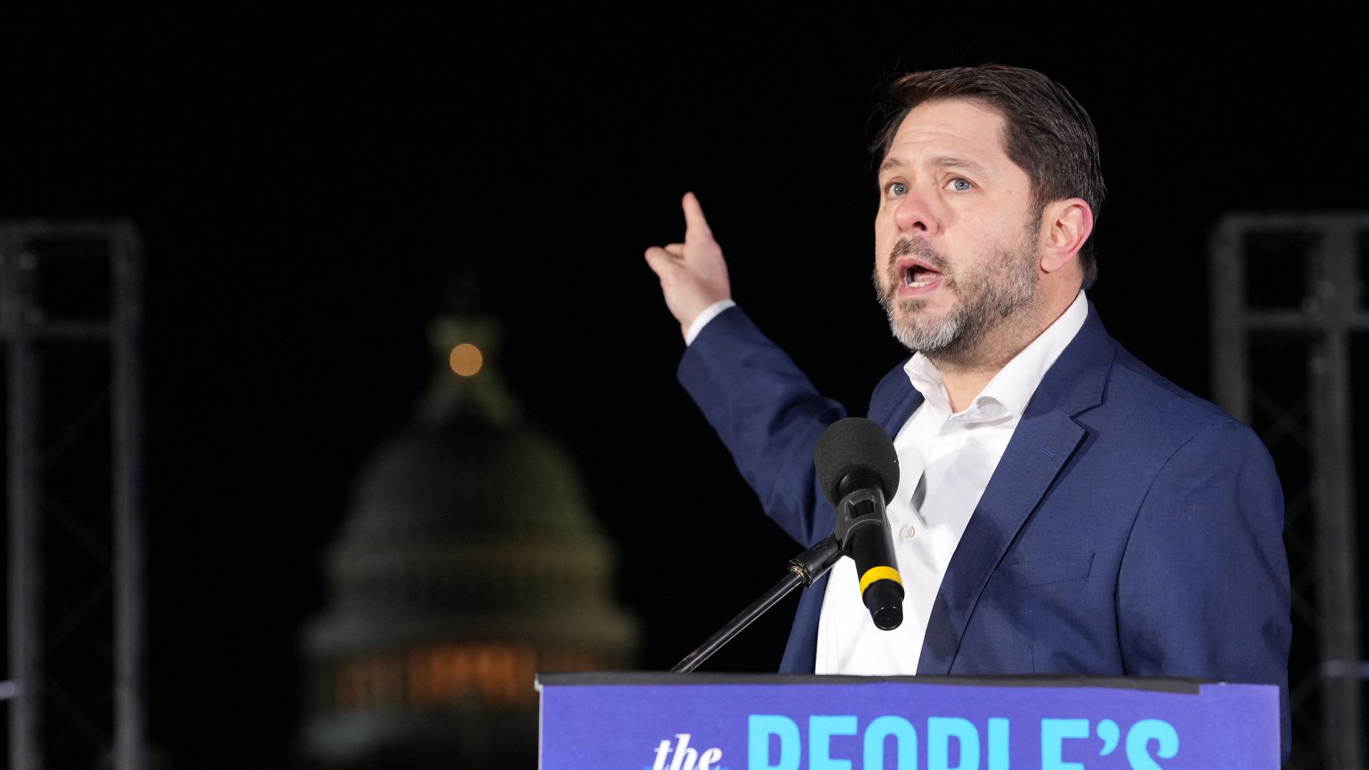 Sen. Ruben Gallego speaks behind a podium that says "The People's State of the Union."
