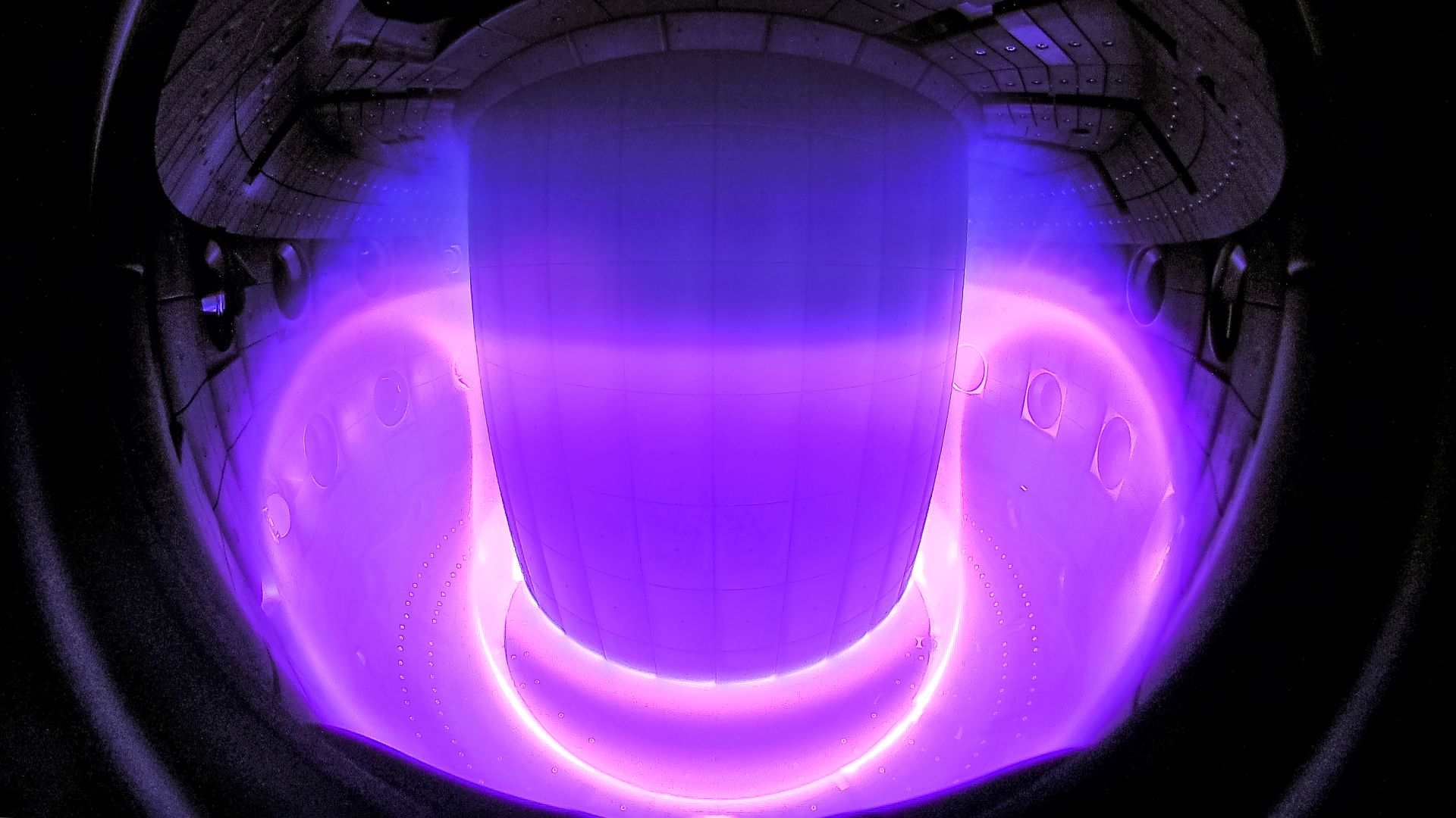 Camera image of a plasma inside the TCV tokamak, regions of different colors correspond to different temperatures of the hot plasma. 
