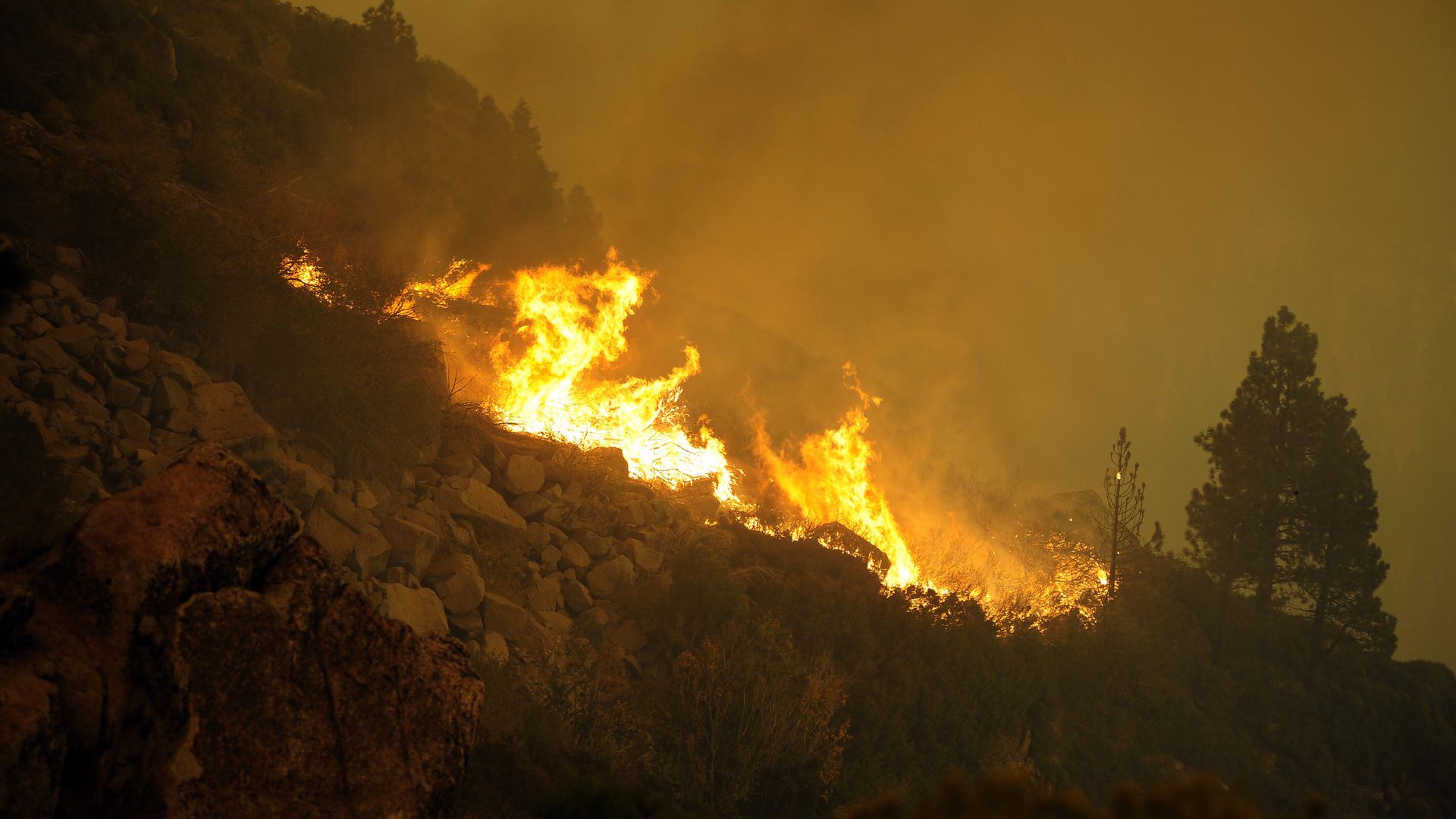 Flames on the side of a rocky hill.