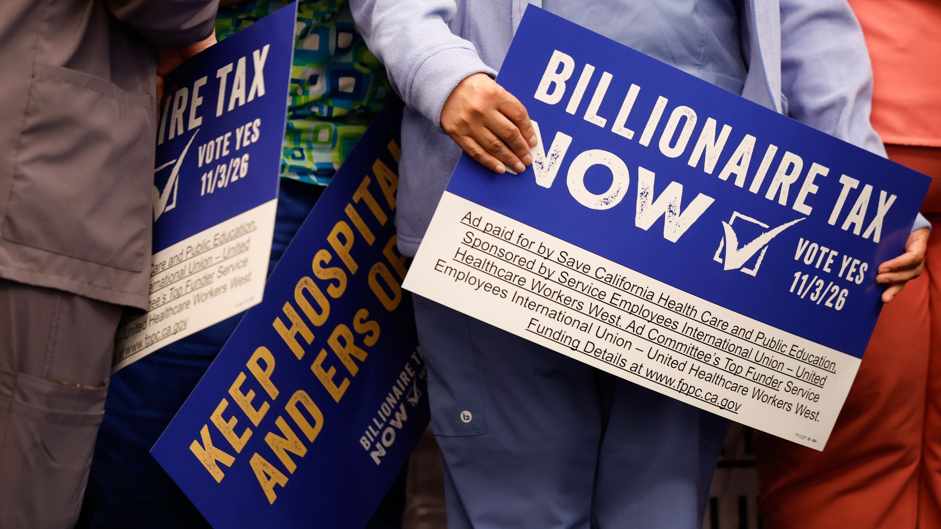 supporters for billionaire tax holding signs of support
