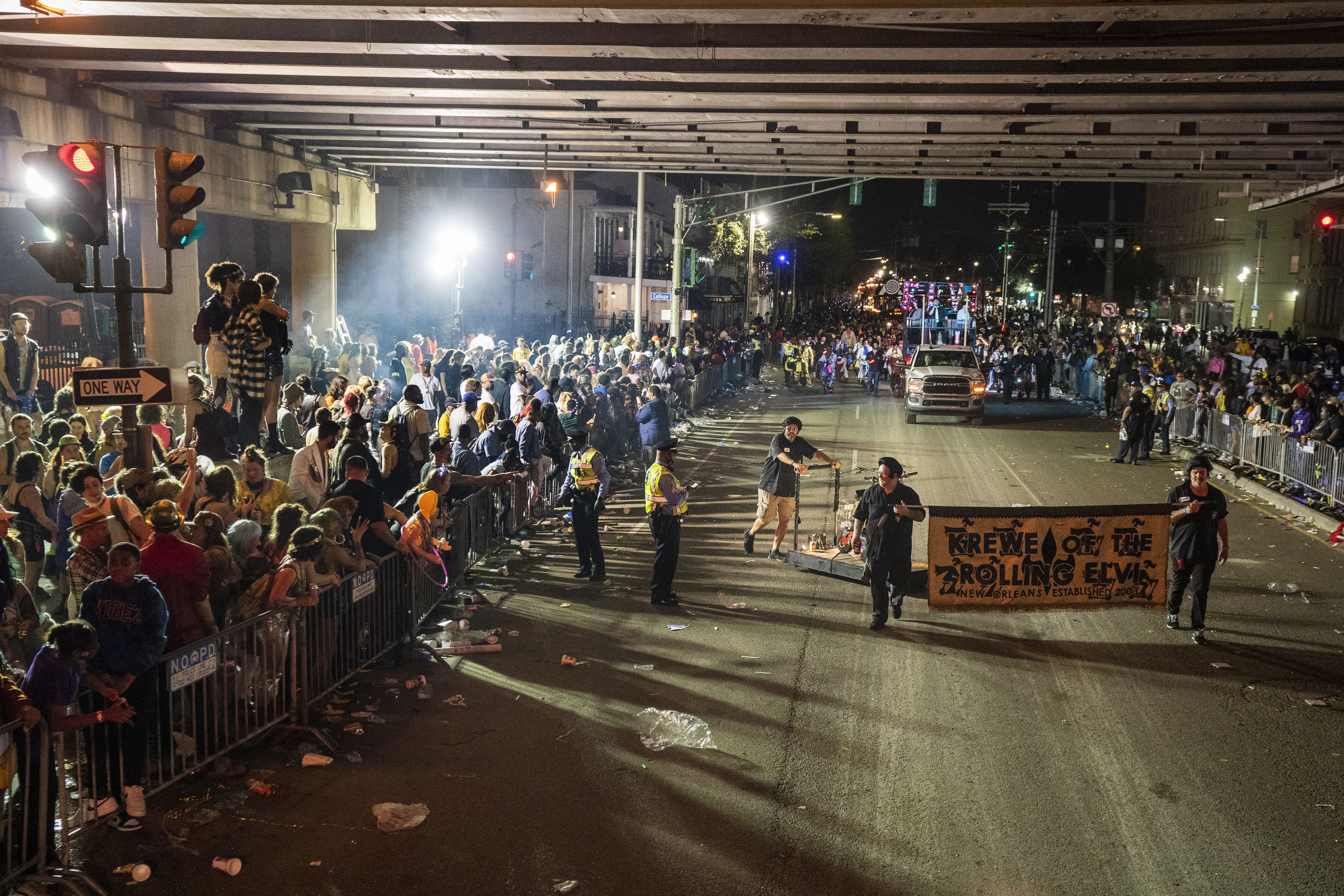 Image shows crowds under the I-10 overpass with a parade.