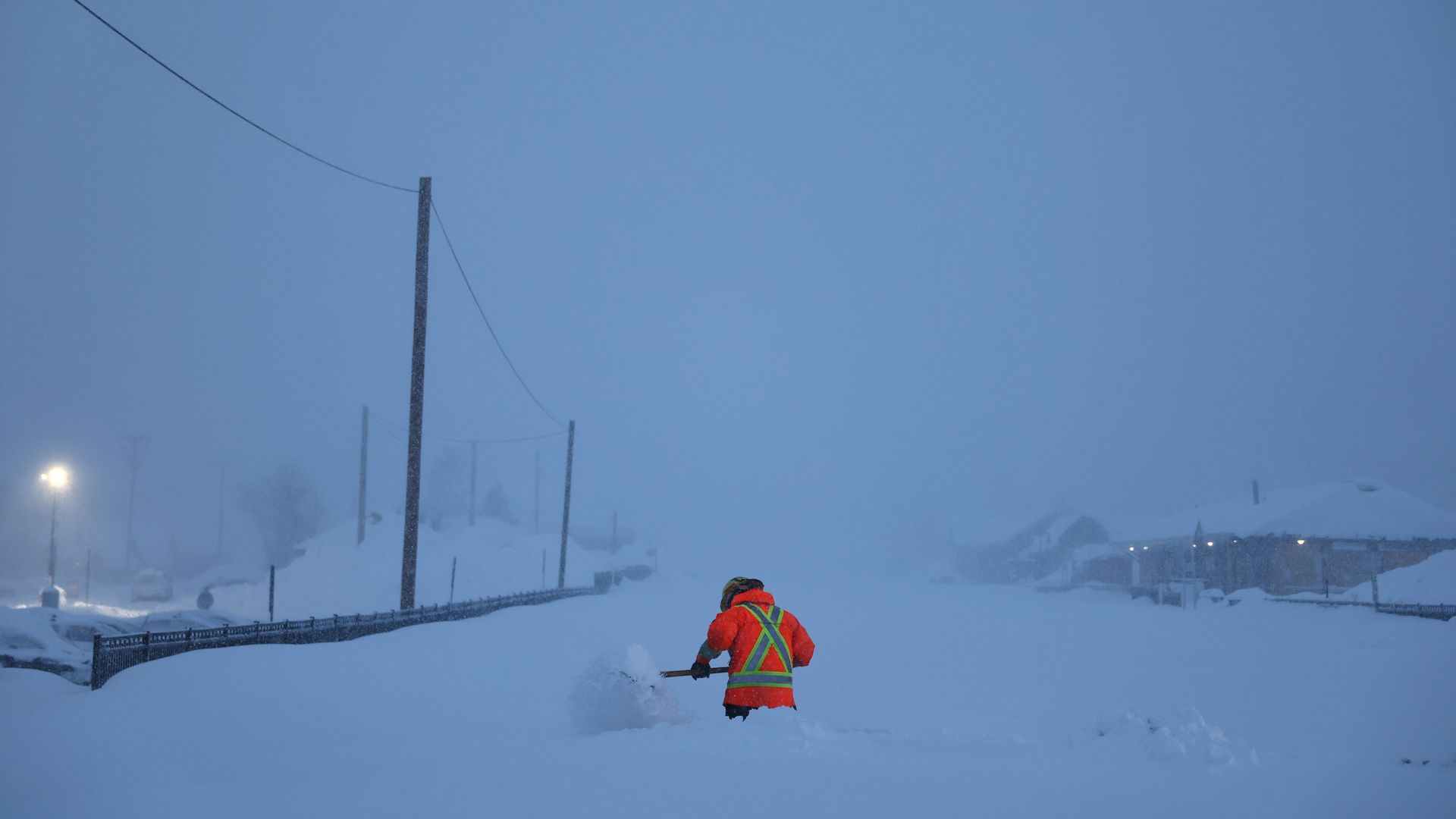Picture of a man shoveling snow near railroad tracks during a blizzard in California's Sierra Nevada Mountains.