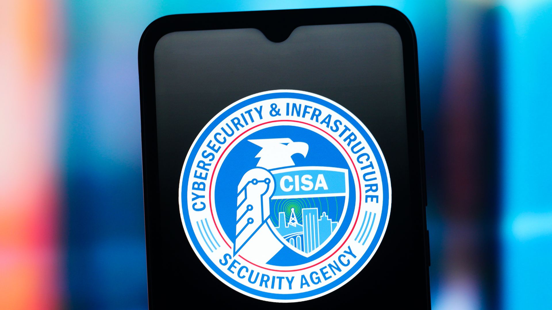 The CISA logo on a phone over a blurred, blue background