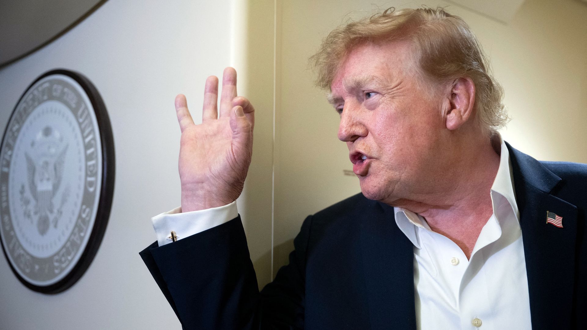 President Trump speaks to reporters aboard Air Force One.