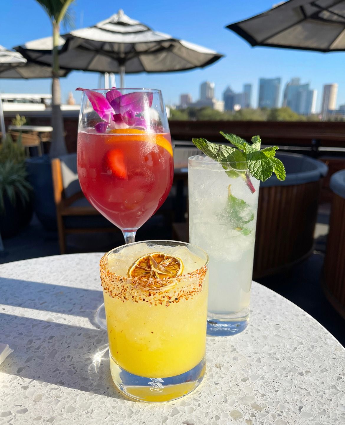 A sangria, margarita and mojito in front of the skyline
