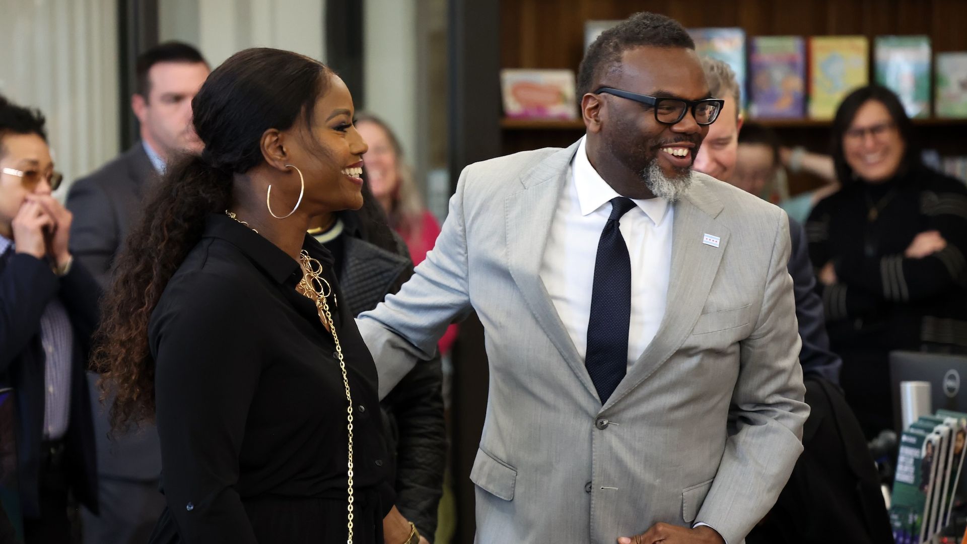 Stacy Davis Gates smiling next to Mayor Brandon Johnson with people in the background.