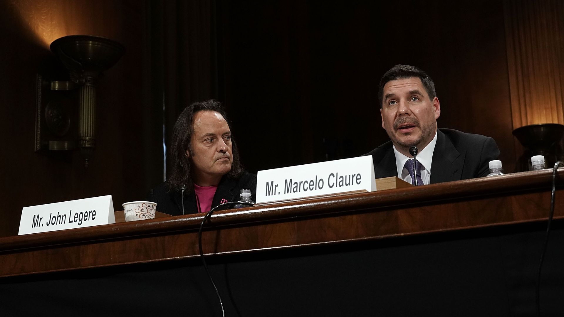 T-Mobile and Sprint's chief executives testify at a wooden table