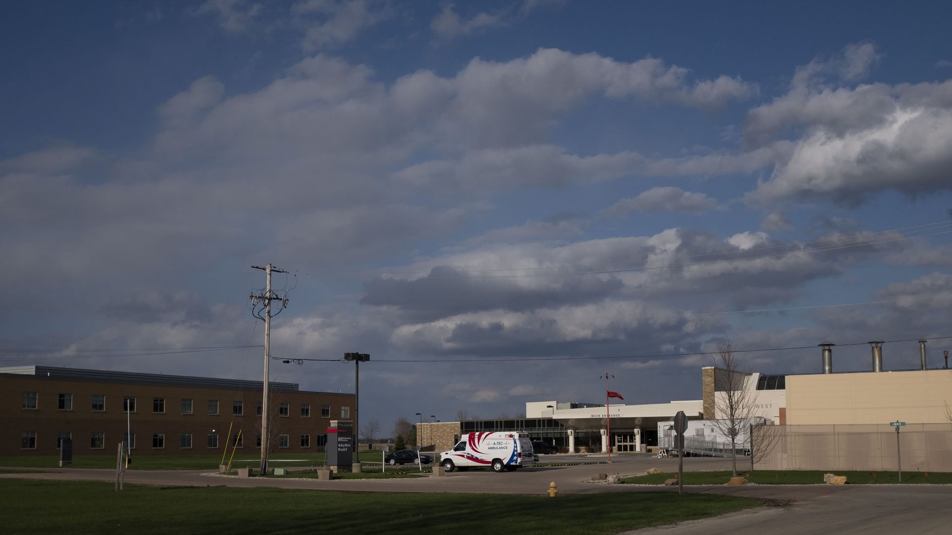 A photo of an ambulance in an empty hospital parking lot.