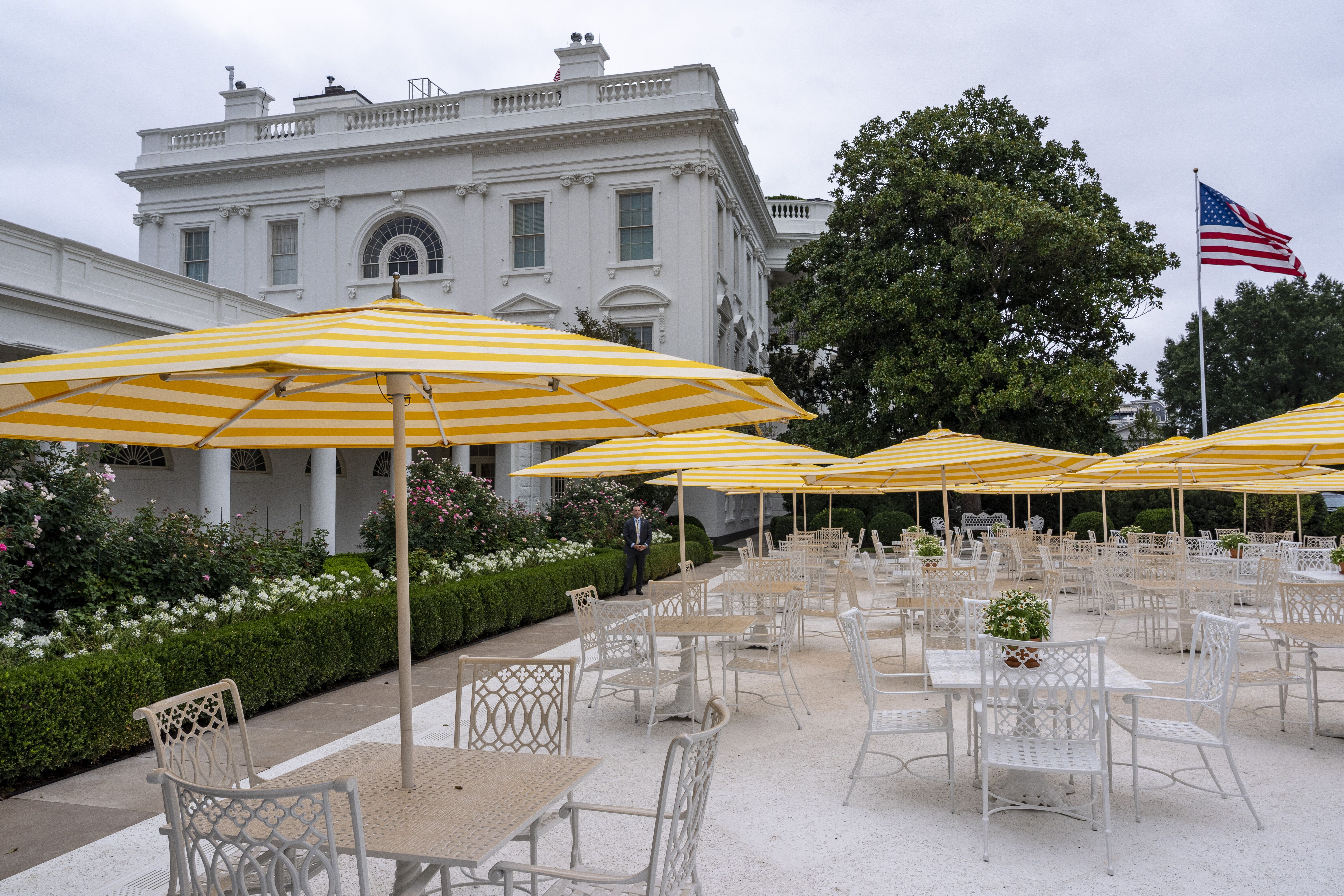 Yellow-and-white striped umbrellas are open in the newly paved Rose Garden, bringing a Mar-a-Lago-patio vibe to the White House. 
