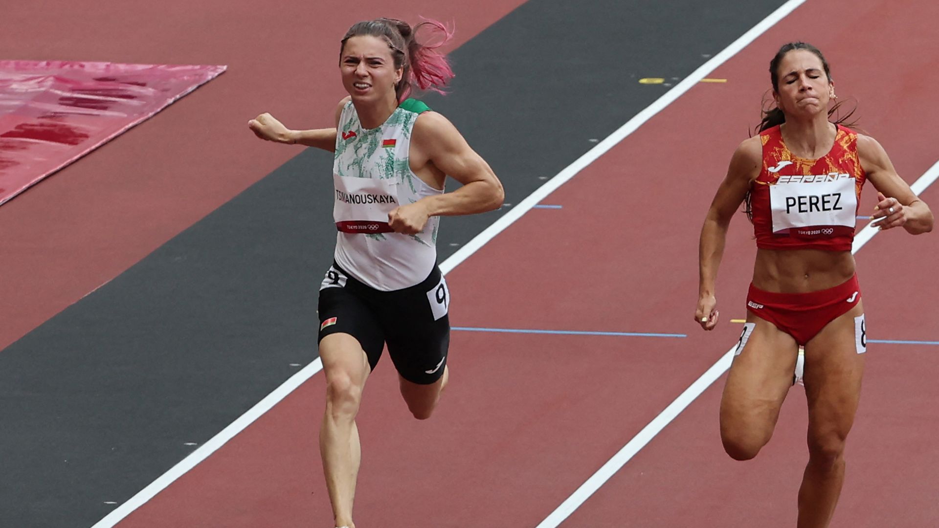 This file photo taken on July 30, 2021 shows Belarus' Krystsina Tsimanouskaya (L) and Spain's Maria Isabel Perez competing in the women's 100m heats 