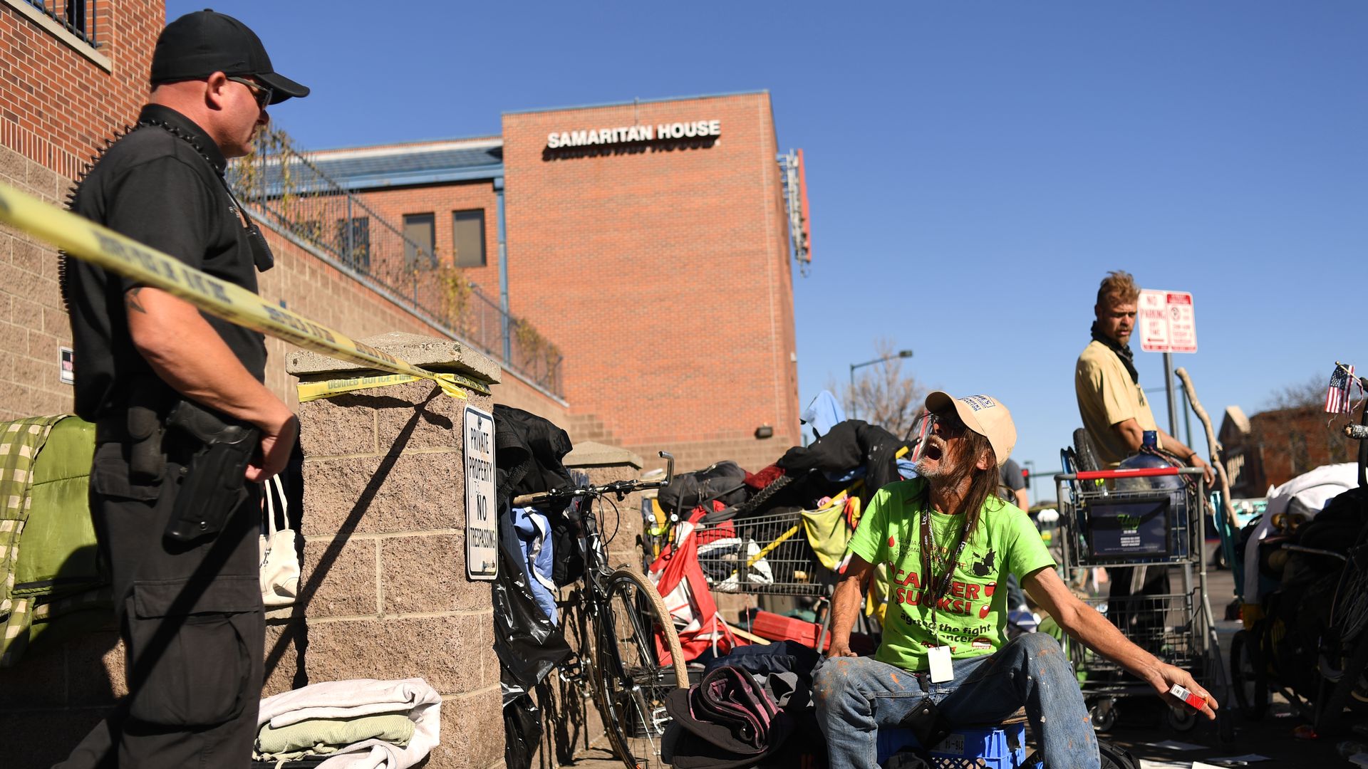 A homeless man arguing with a Denver police officer at an encampment sweep.