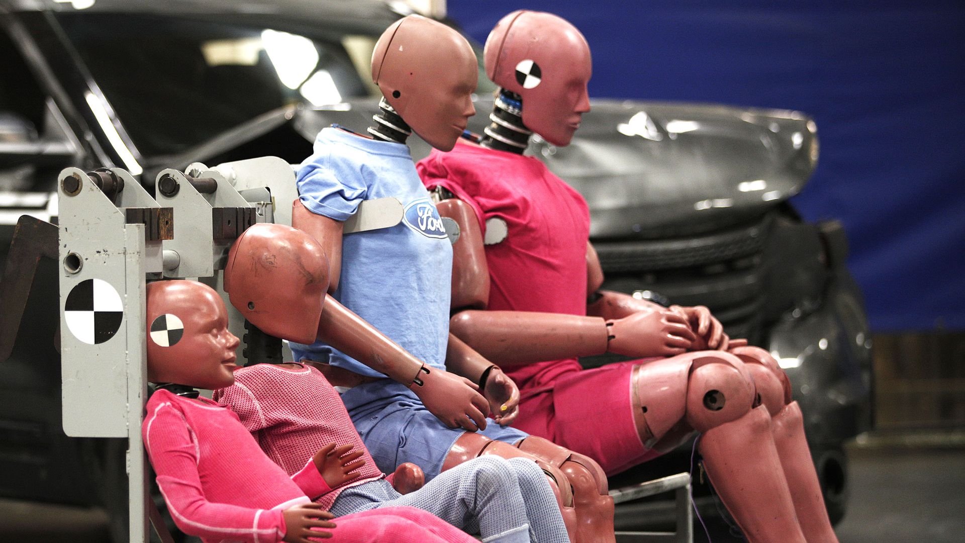 a family of Ford crash test dummies at an auto testing warehouse