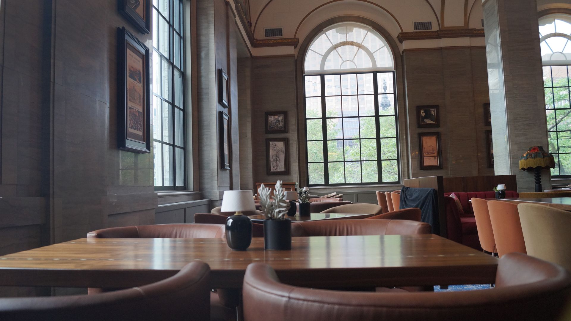 The interior of a swanky hotel restaurant with a tall window