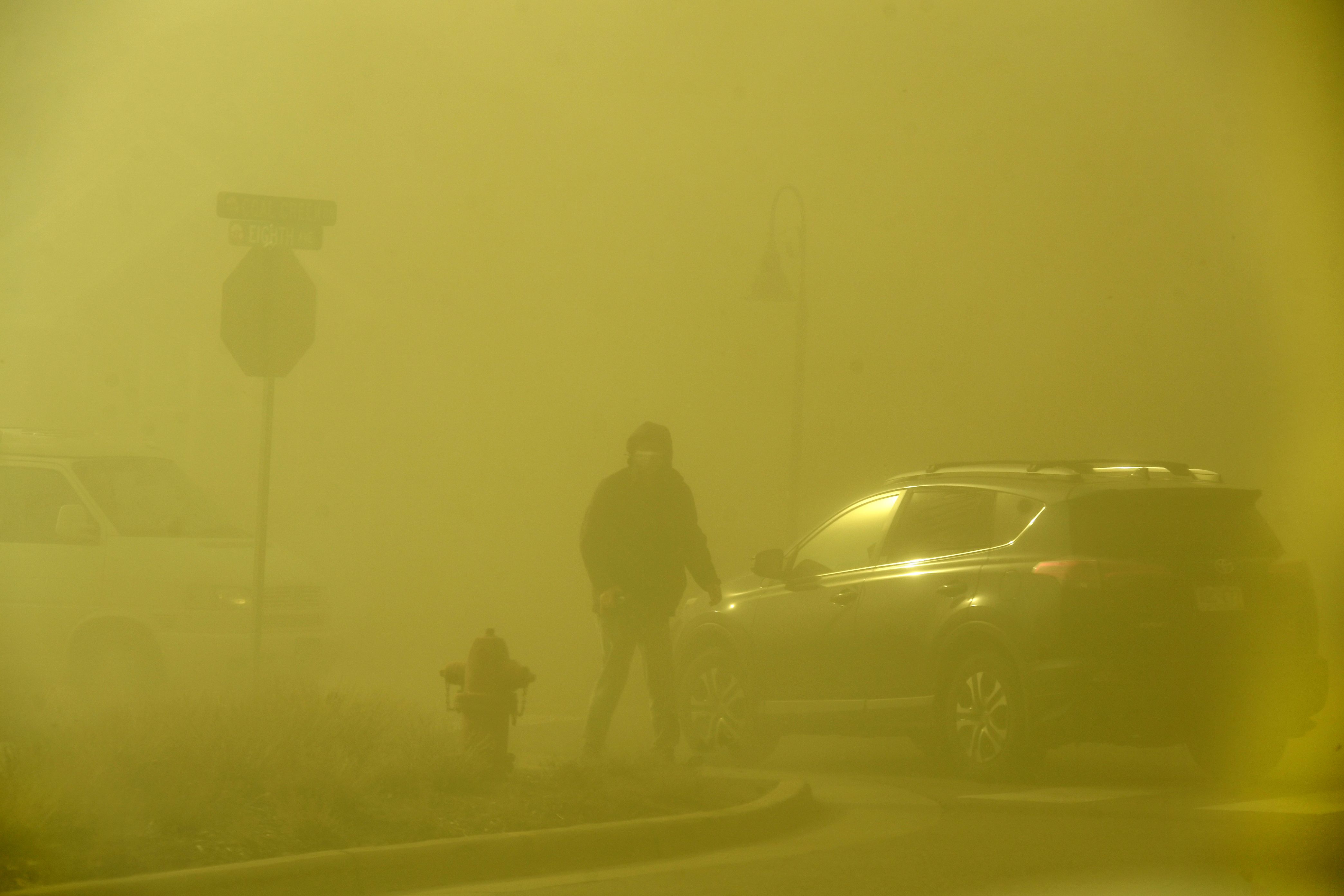 People try to put out fire along a median with water bottles in neighborhoods on December 30, 2021 in Superior.