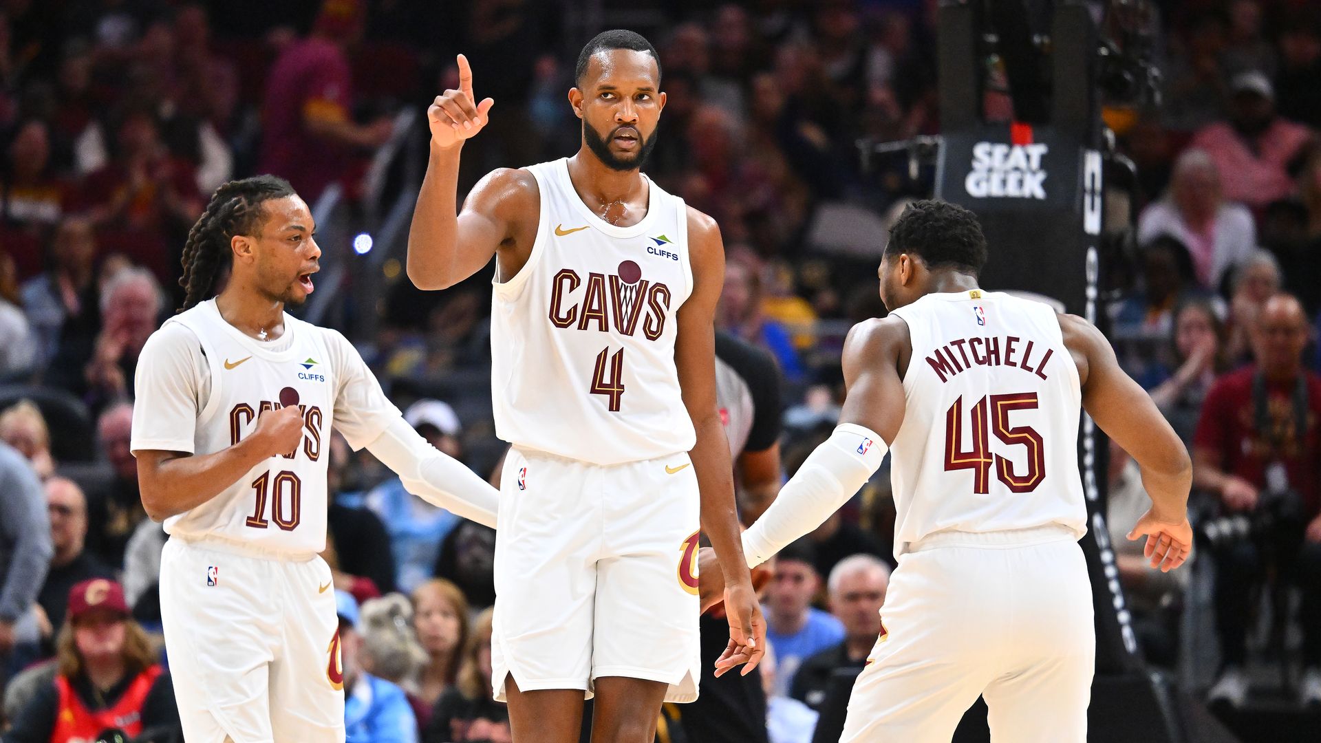 Cavs in white jerseys, L-R: Darius Garland, Evan Mobley, Donovan Mitchell 