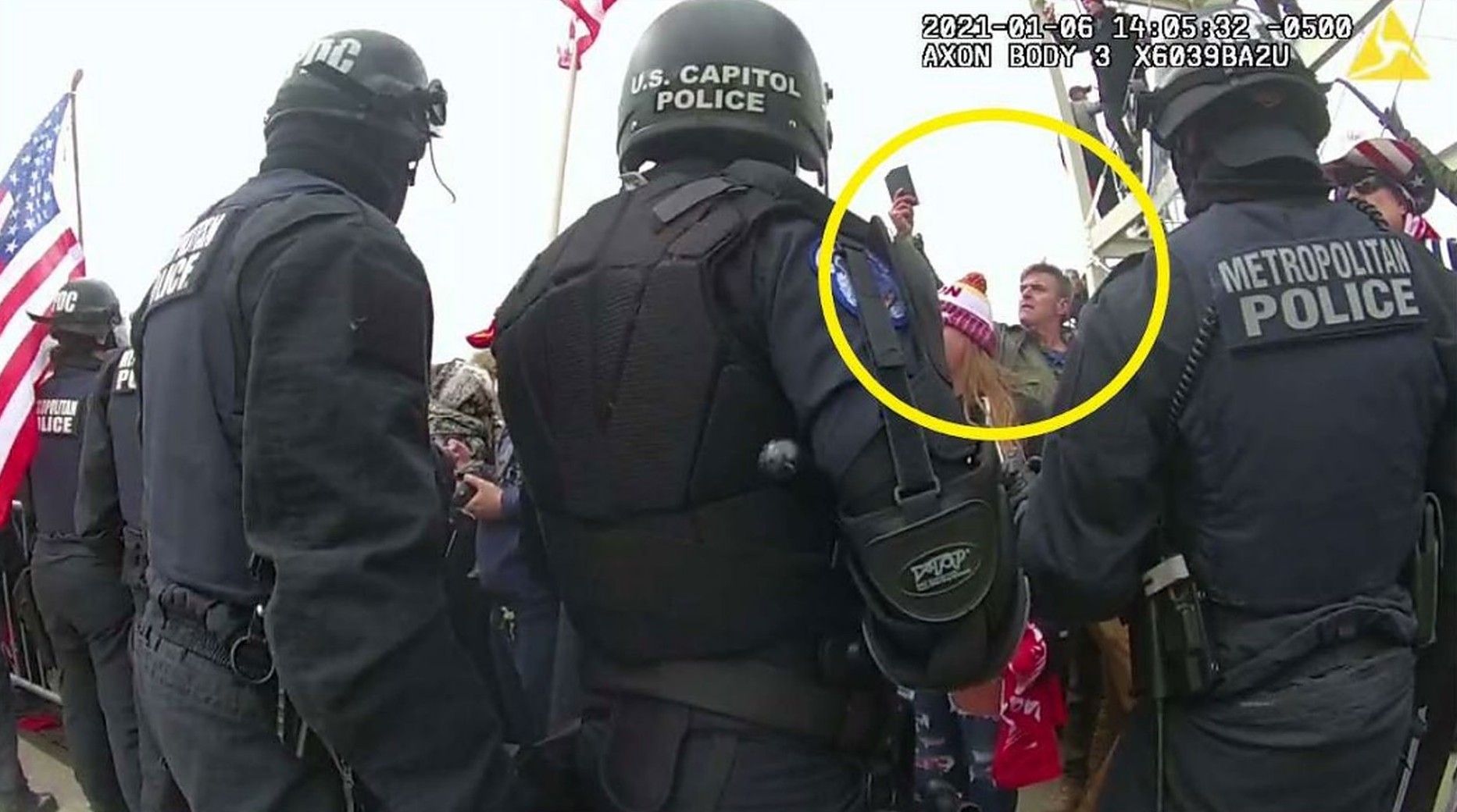 A man (circled) identified by prosecutors as Jay James Johnston wearing a green camouflage neck gaiter and a dark leather jacket.