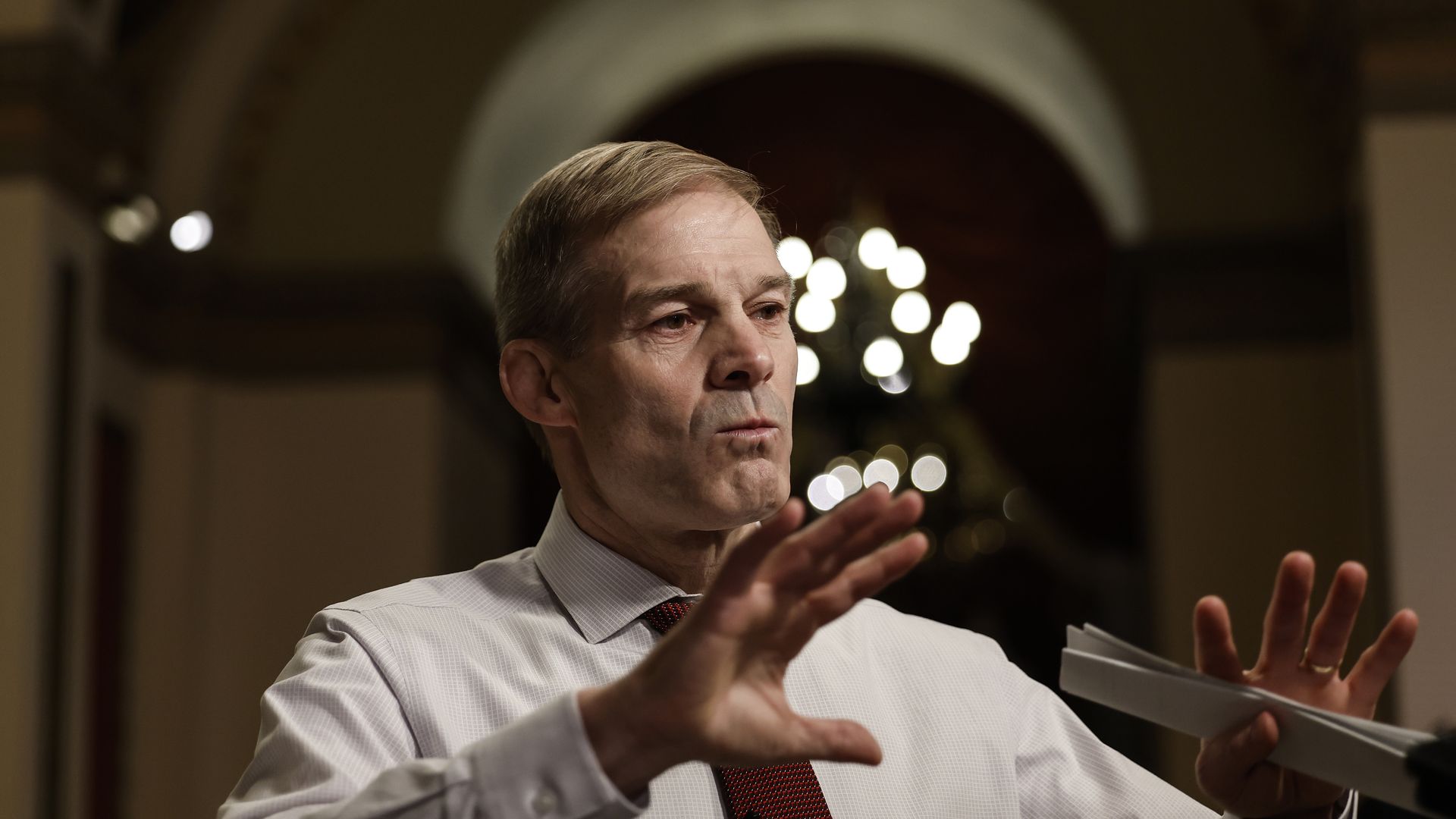 Rep. Jim Jordan, wearing a white shirt and red tie, speaks to reporters at the Capitol.