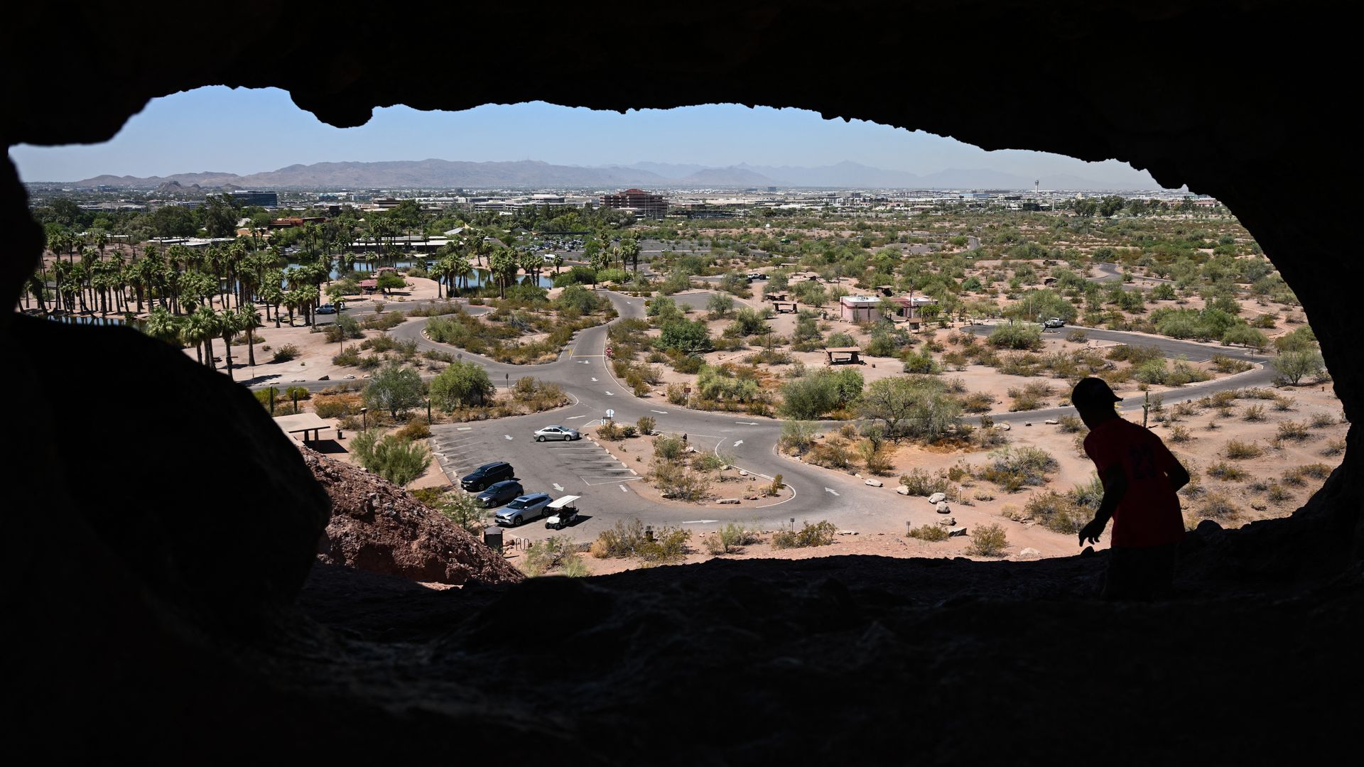 A hiker against a hole in a mountain. 
