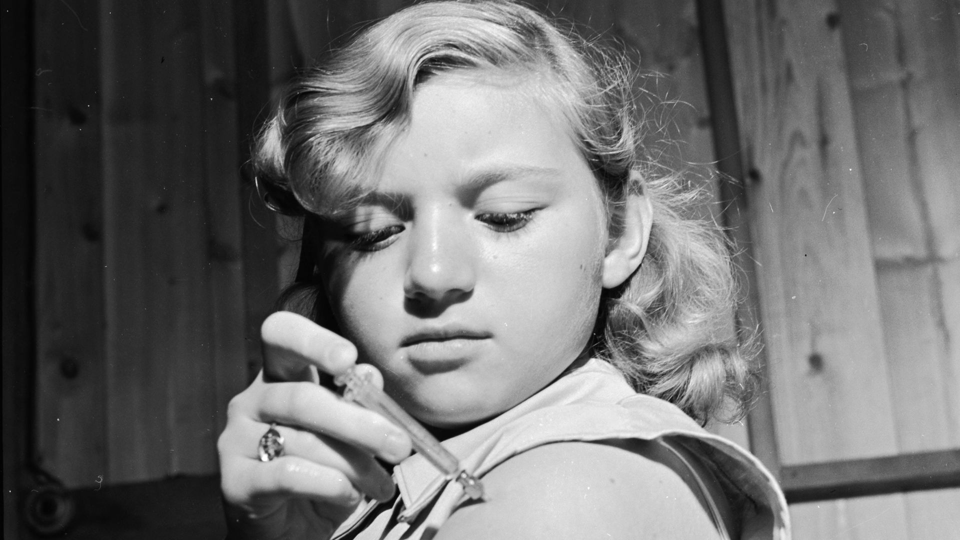 circa 1950: A diabetic girl injecting her arm with insulin.