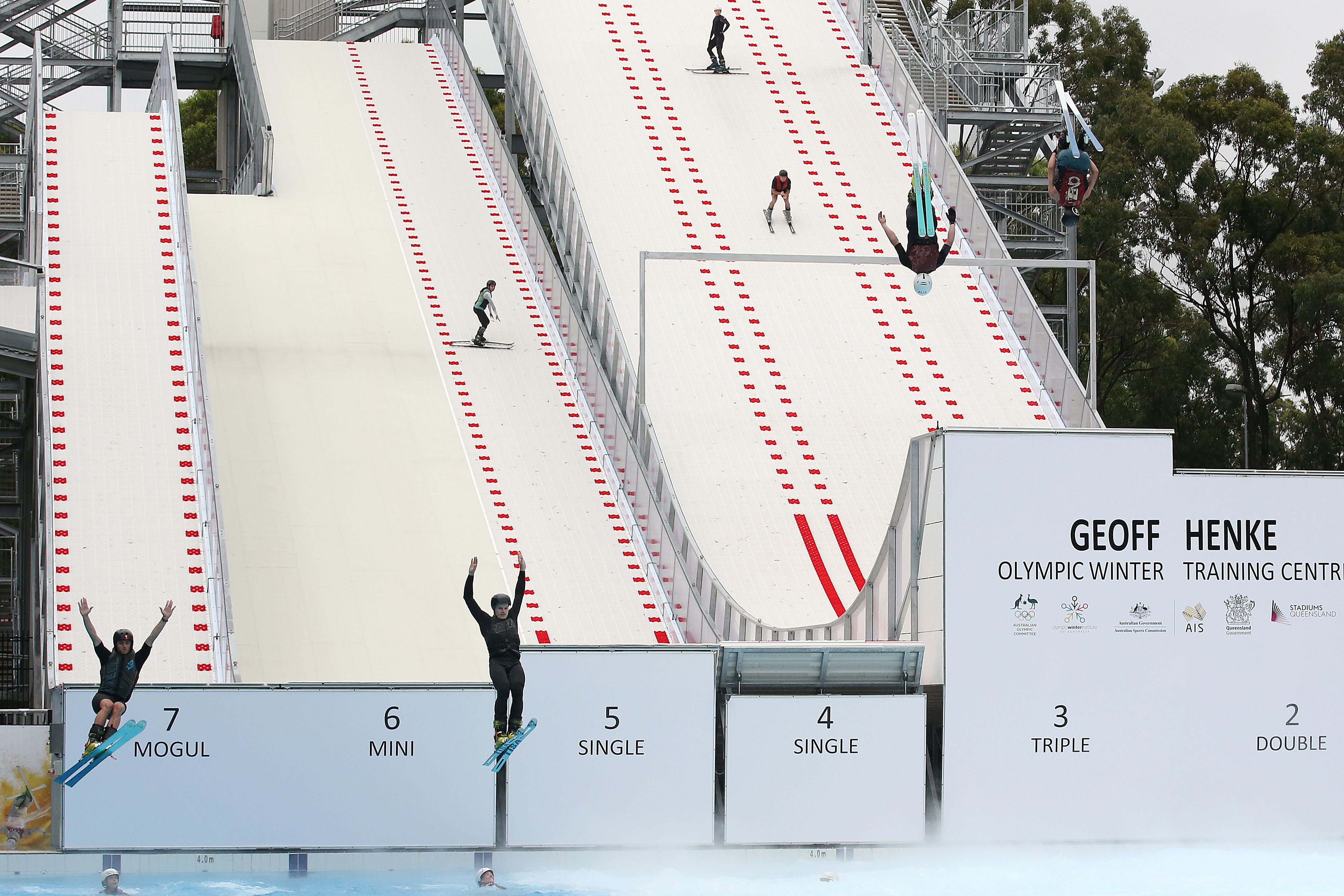 Skiers jumping into a pool