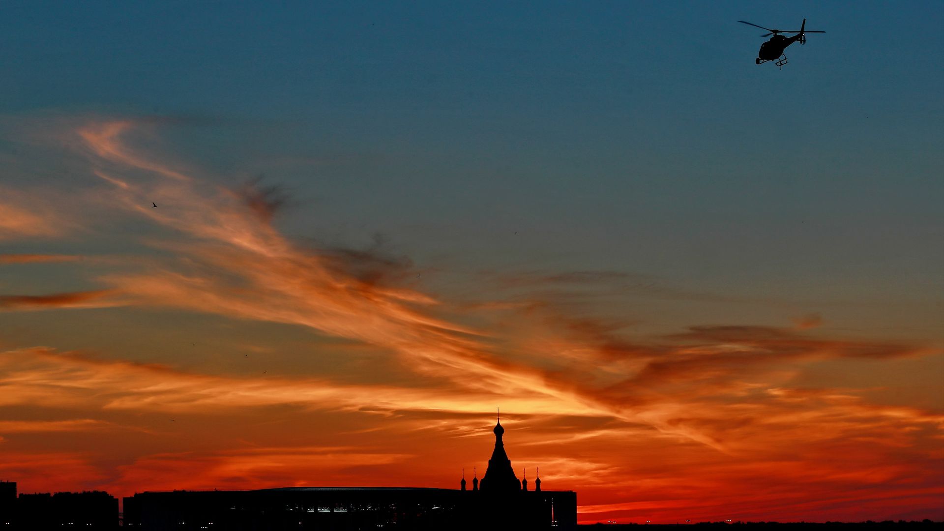 A helicopter flying during sunset