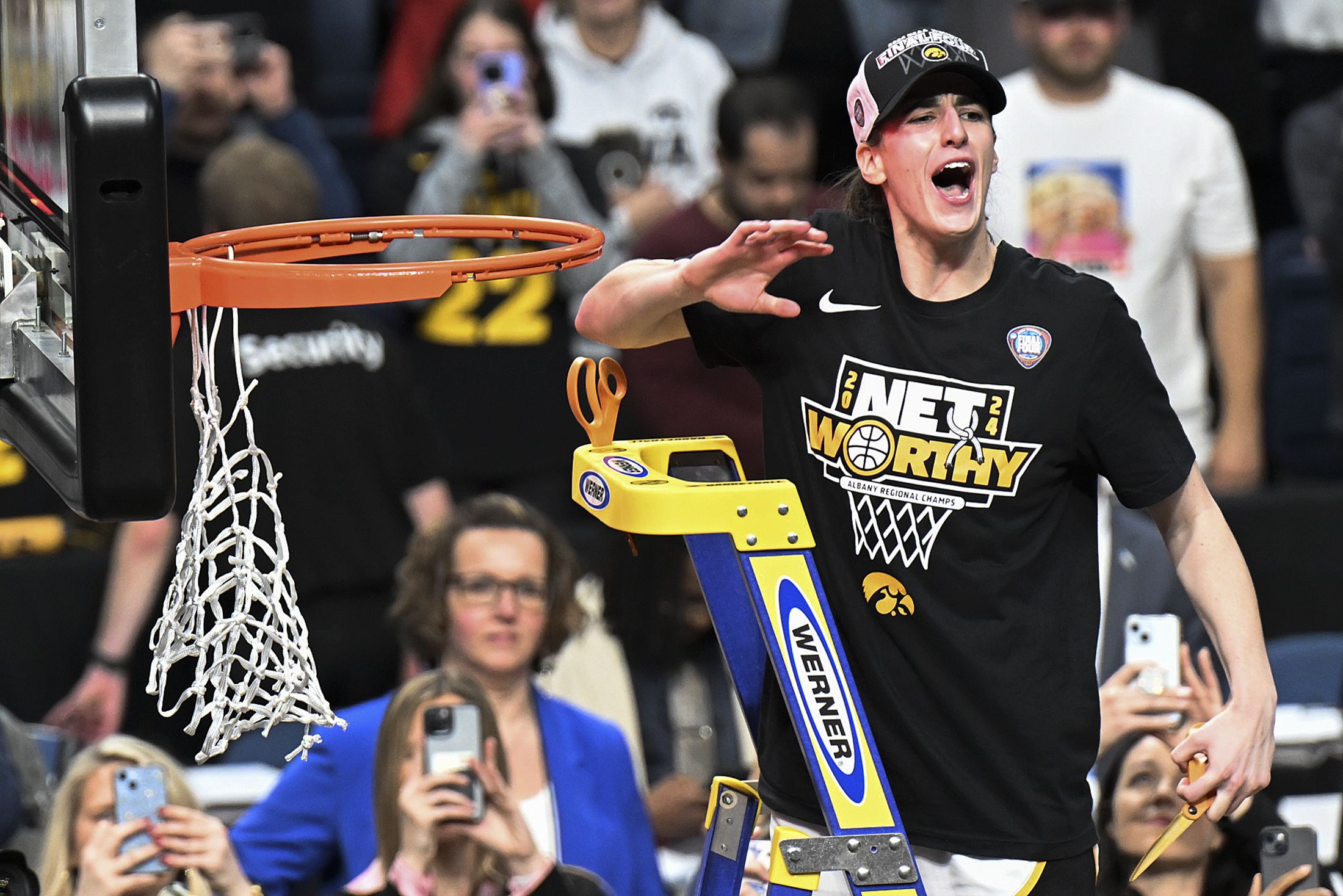 Iowa's Caitlin Clark cuts off a piece of the net after clinching a spot in the Final Four on Monday. 