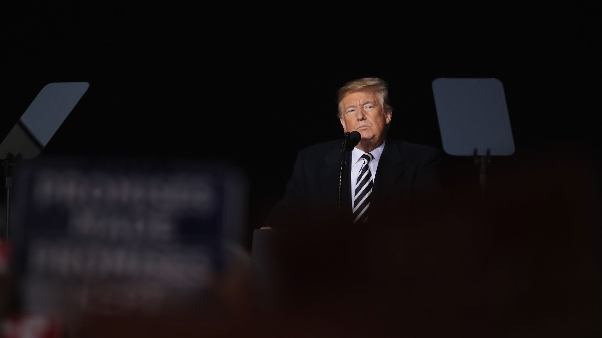President Trump standing in front of a microphone