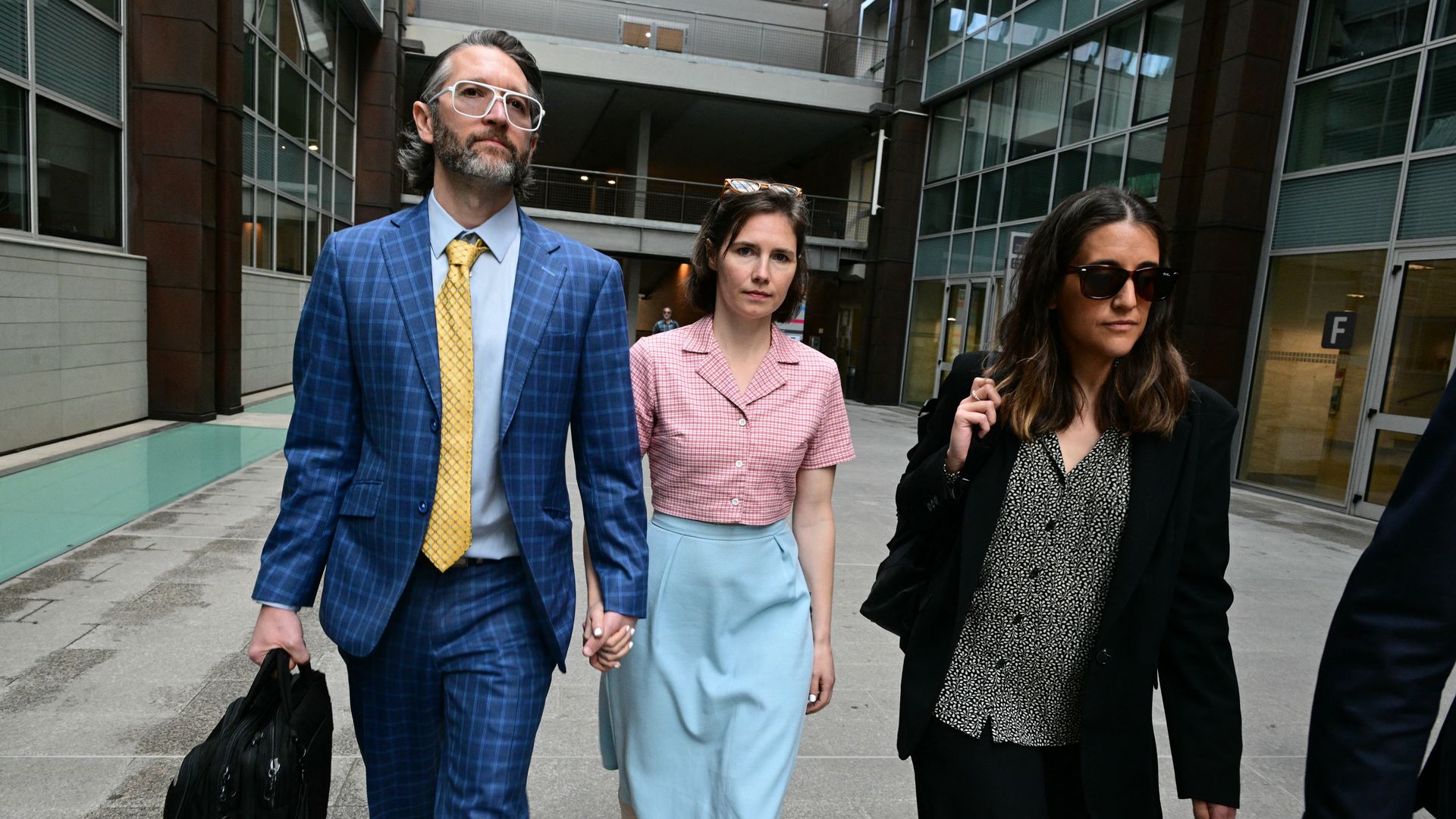 Flanked by a lawyer and her husband, Seattle's Amanda Knox heads to a courtroom in Italy. 