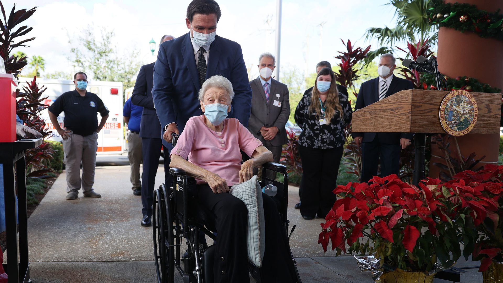 Florida Gov. Ron DeSantis pushes a woman in a wheelchair