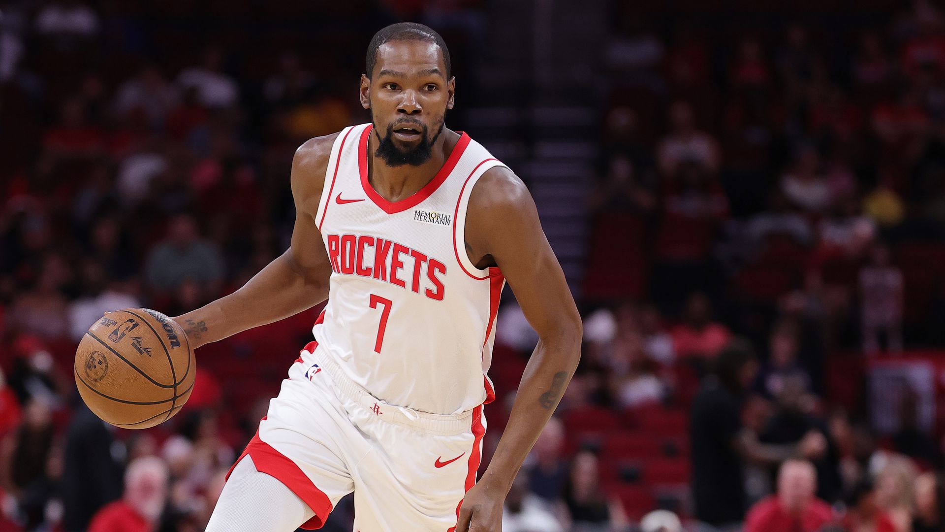 Houston Rockets' forward Kevin Durant, wearing a white uniform with red lettering, hustles with the ball during a preseason matchup