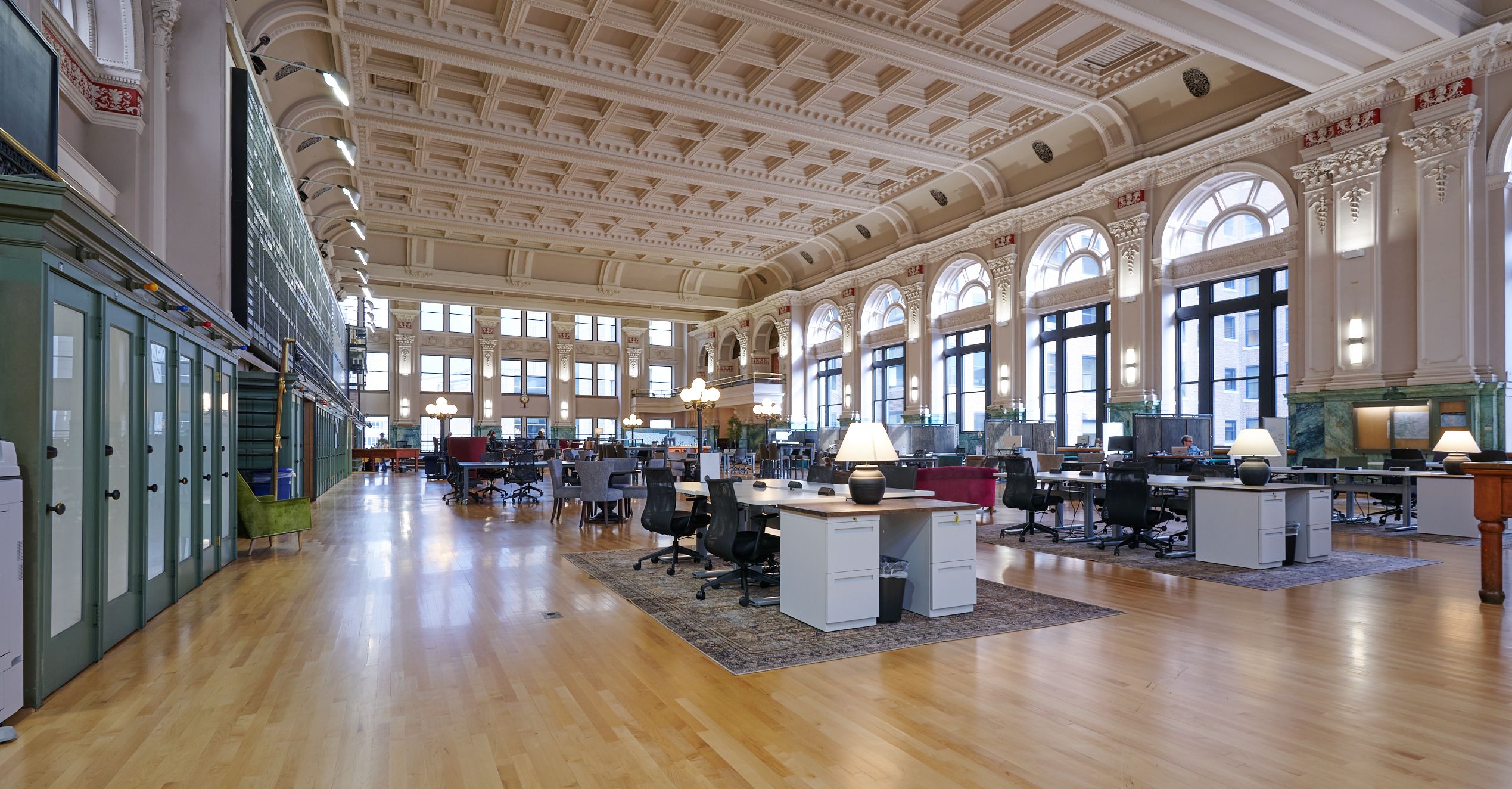 An open trading floor area with a vaulted ceiling, hardwood floors and desks