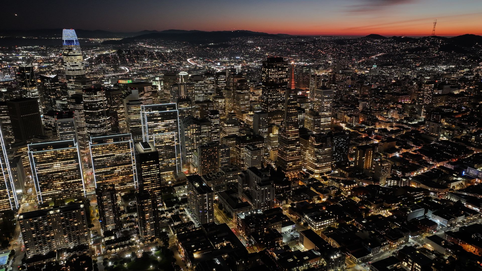 Photo of the San Francisco skyline lit up as the sun sets in the background