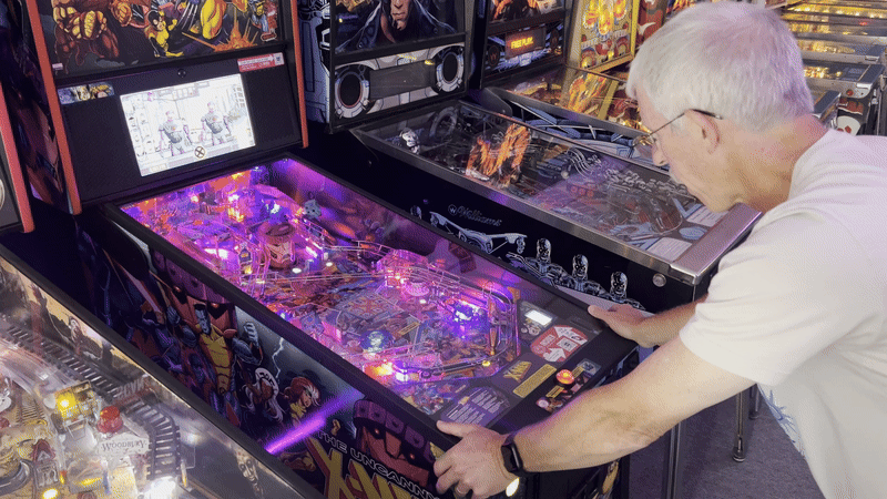a video of a man playing pinball
