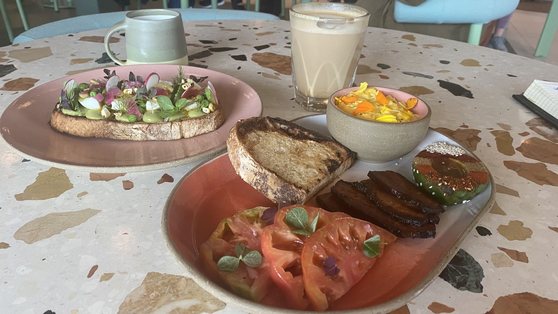 A photo of two colorful plates of breakfast food and two cups of coffee. 