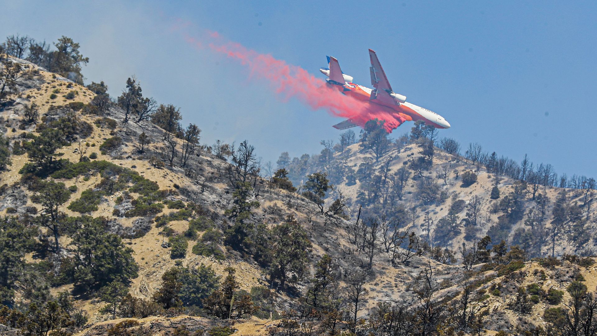 A 10 Tanker DC-10 jet delivers fire retardant as crews continue to battle the Sheep Fire on Monday.