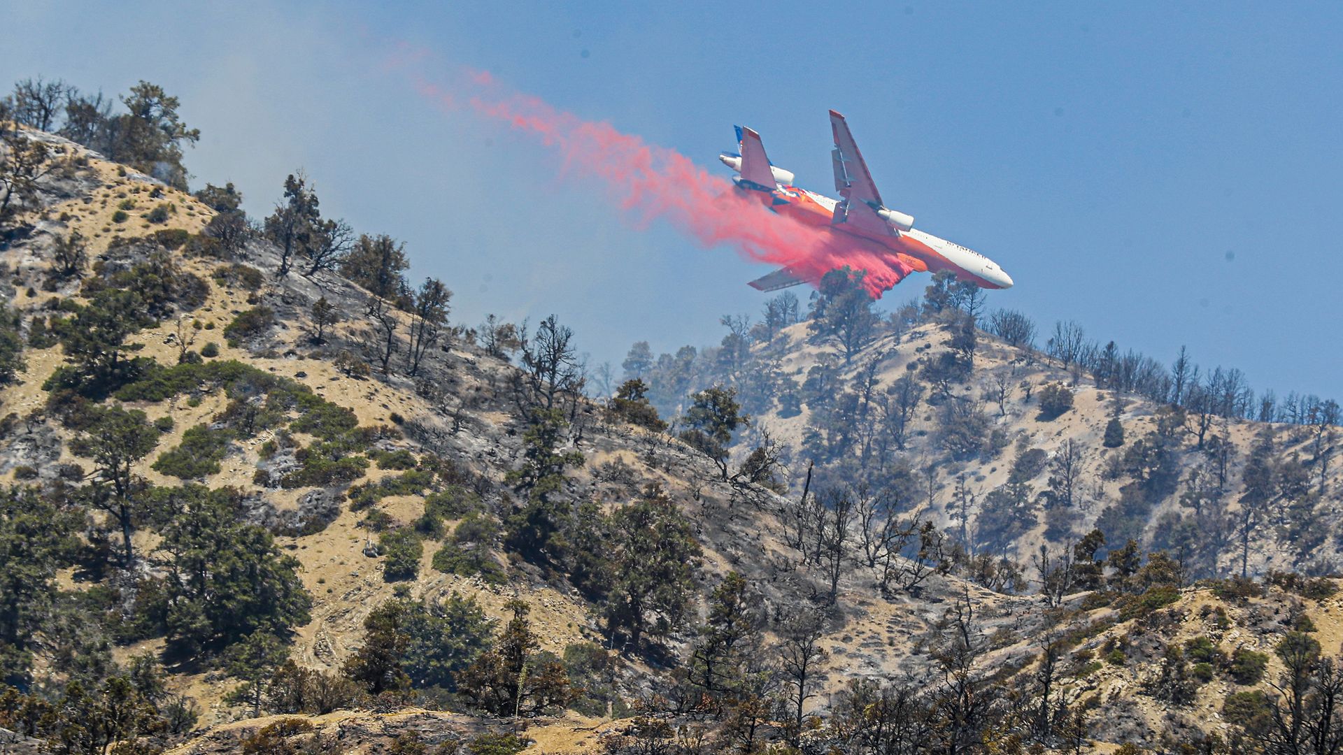 A 10 Tanker DC-10 jet delivers fire retardant as crews continue to battle the Sheep Fire on Monday.